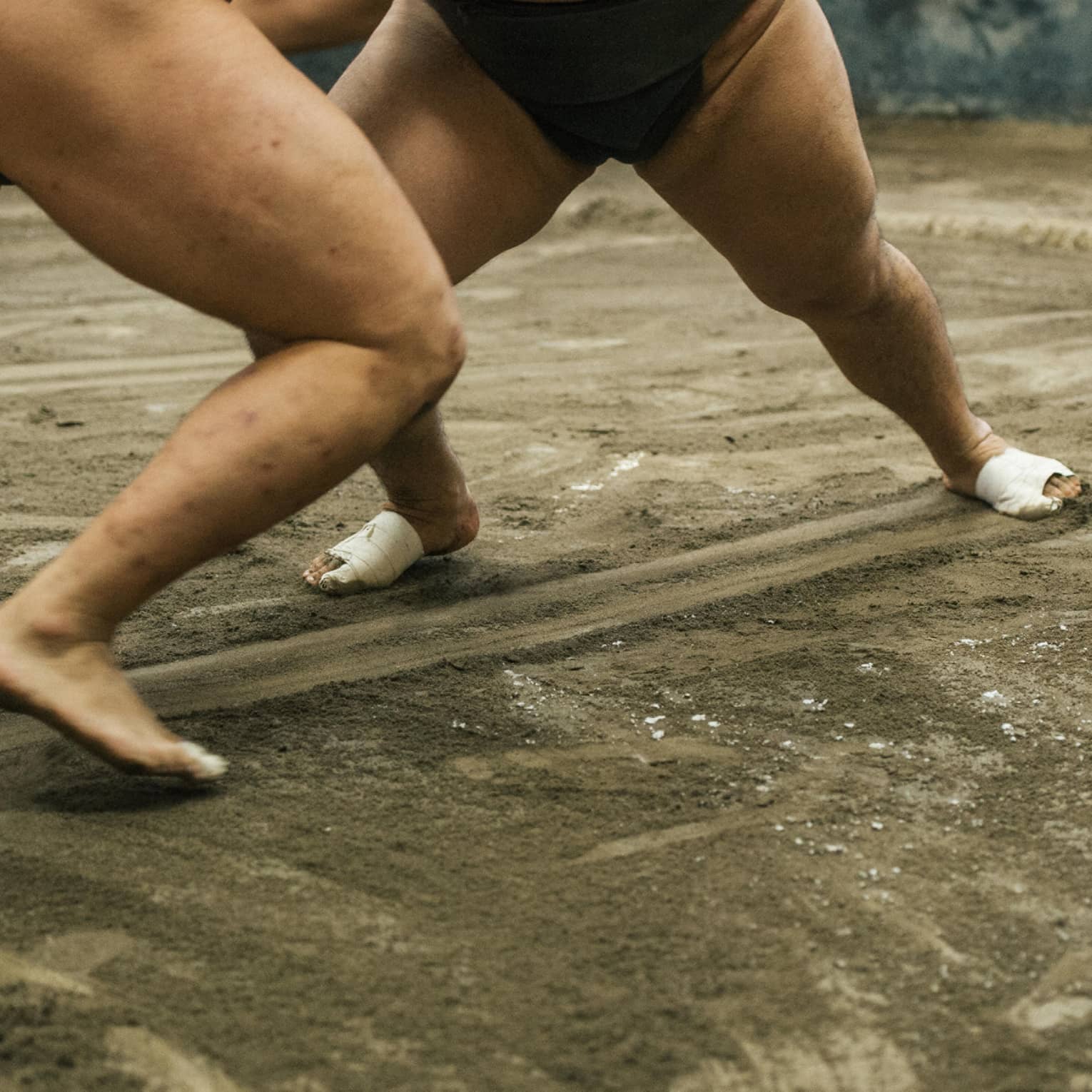 Two sumo wrestlers participate in a match