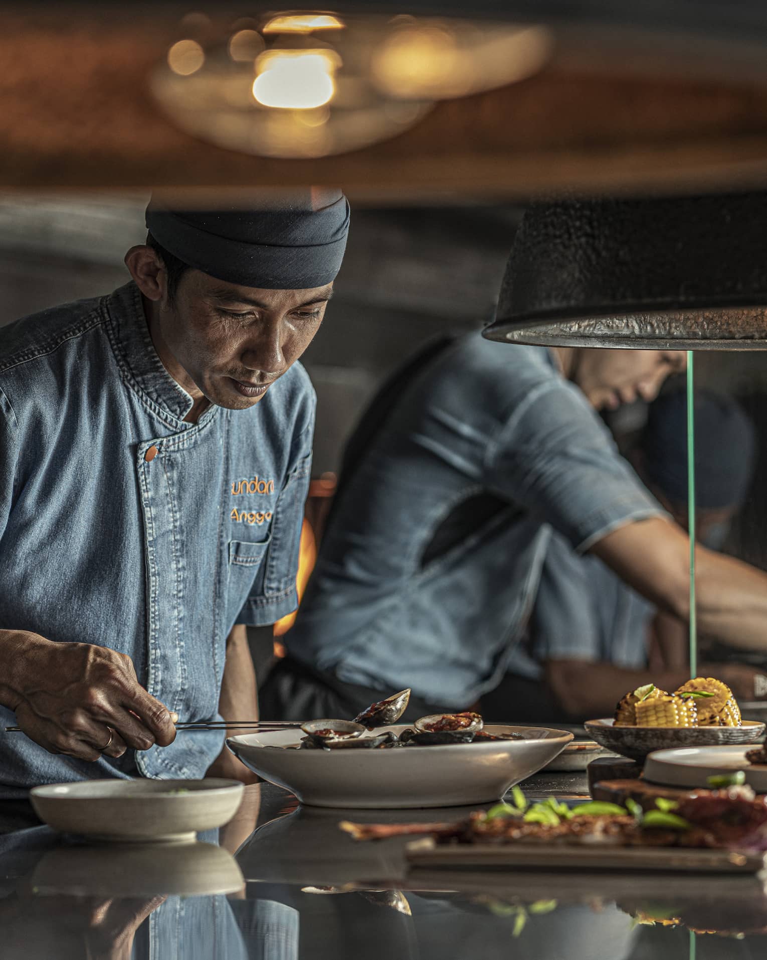 Two chefs put finishing touches on dishes at Sundara