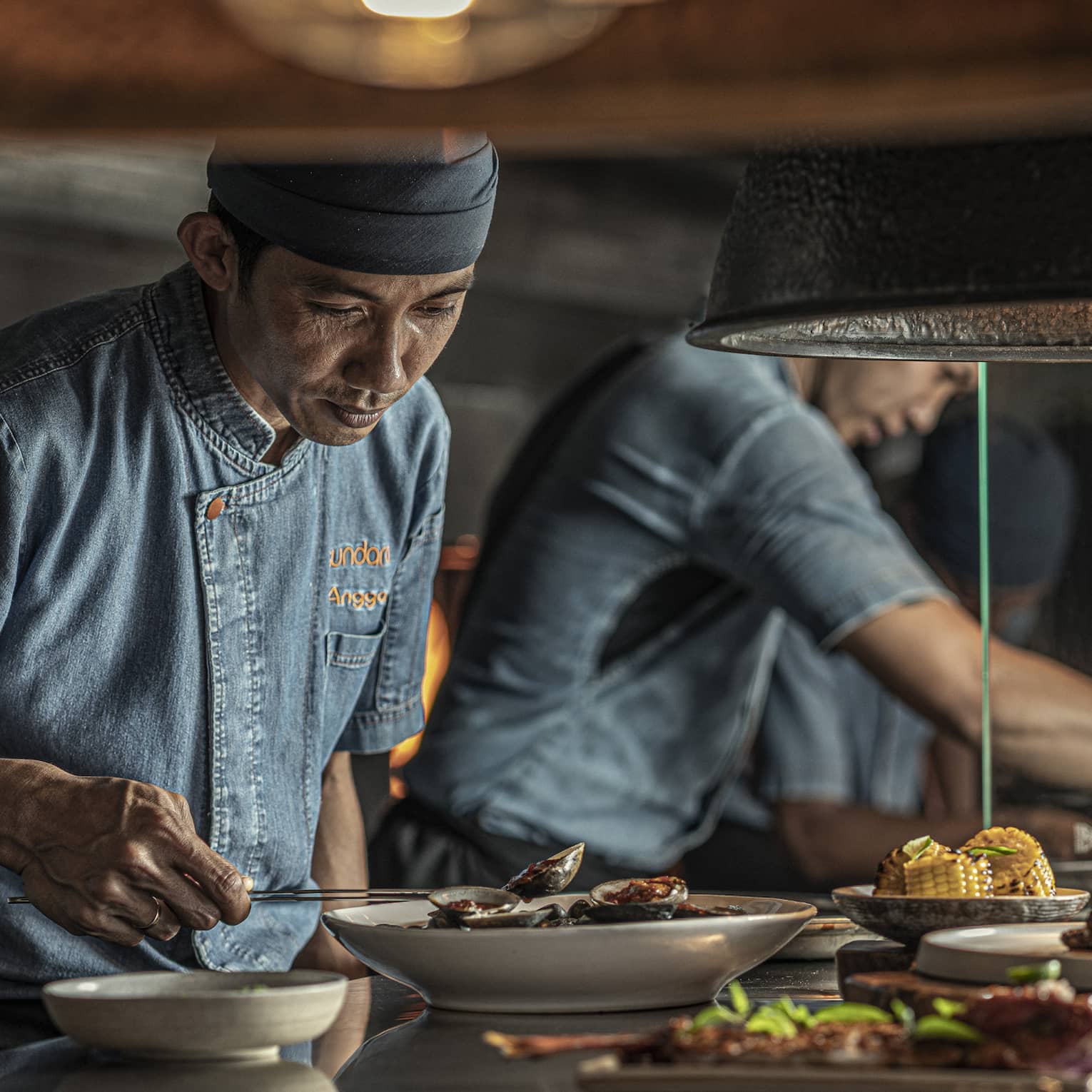 Two chefs put finishing touches on dishes at Sundara