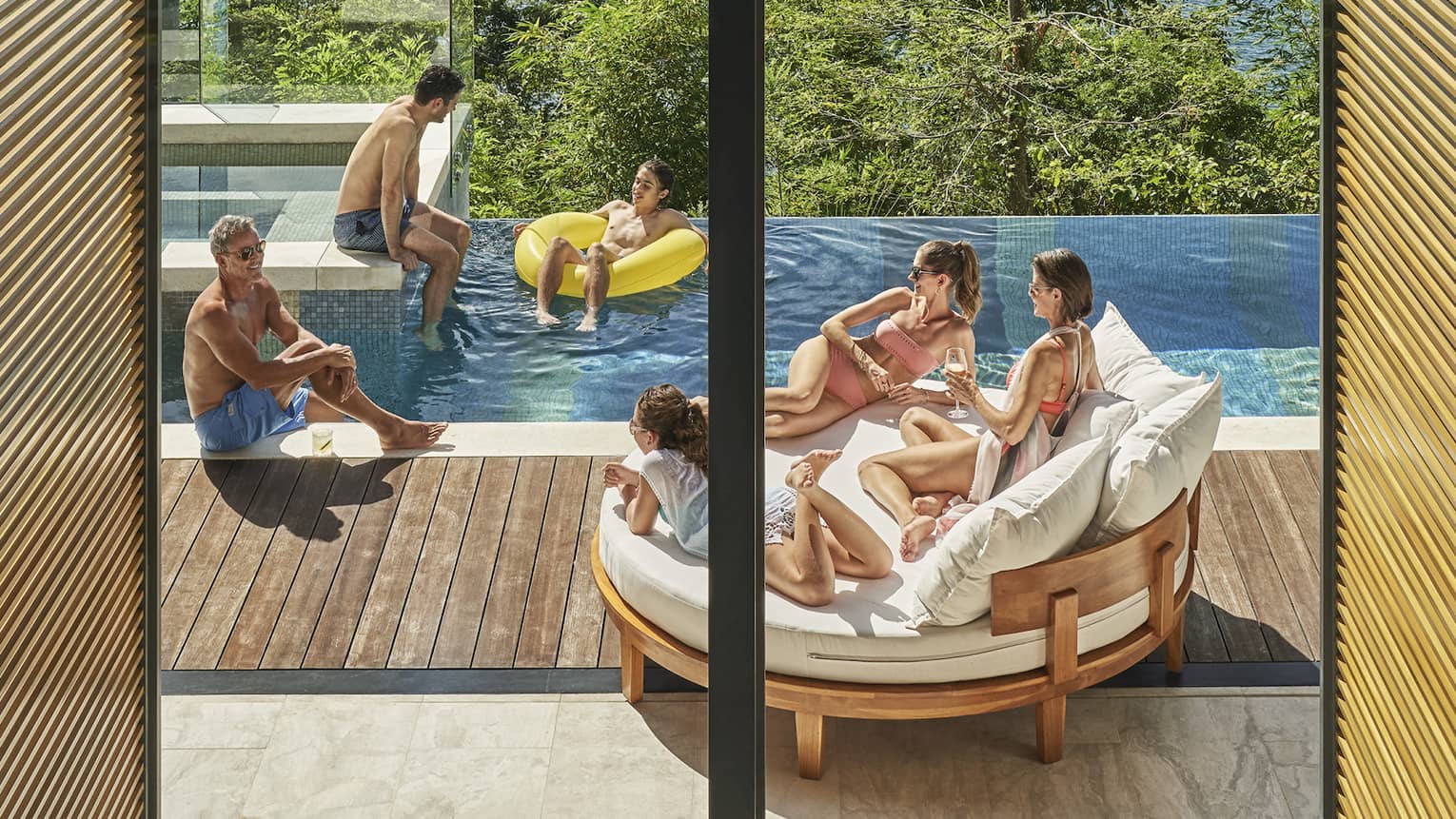 Family in private villa pool with ocean view