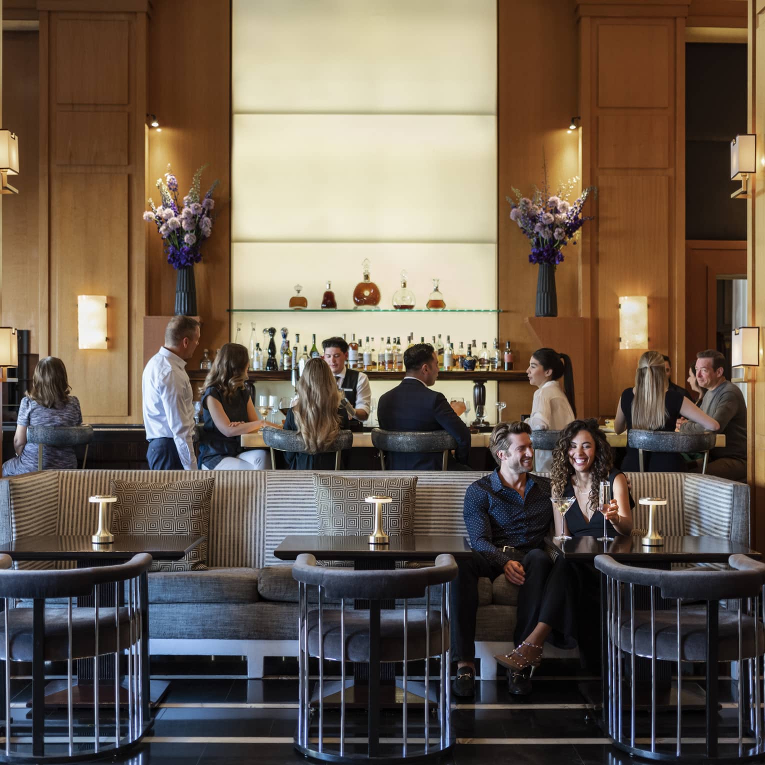 People sitting at a bar and booth in a dining outlet.