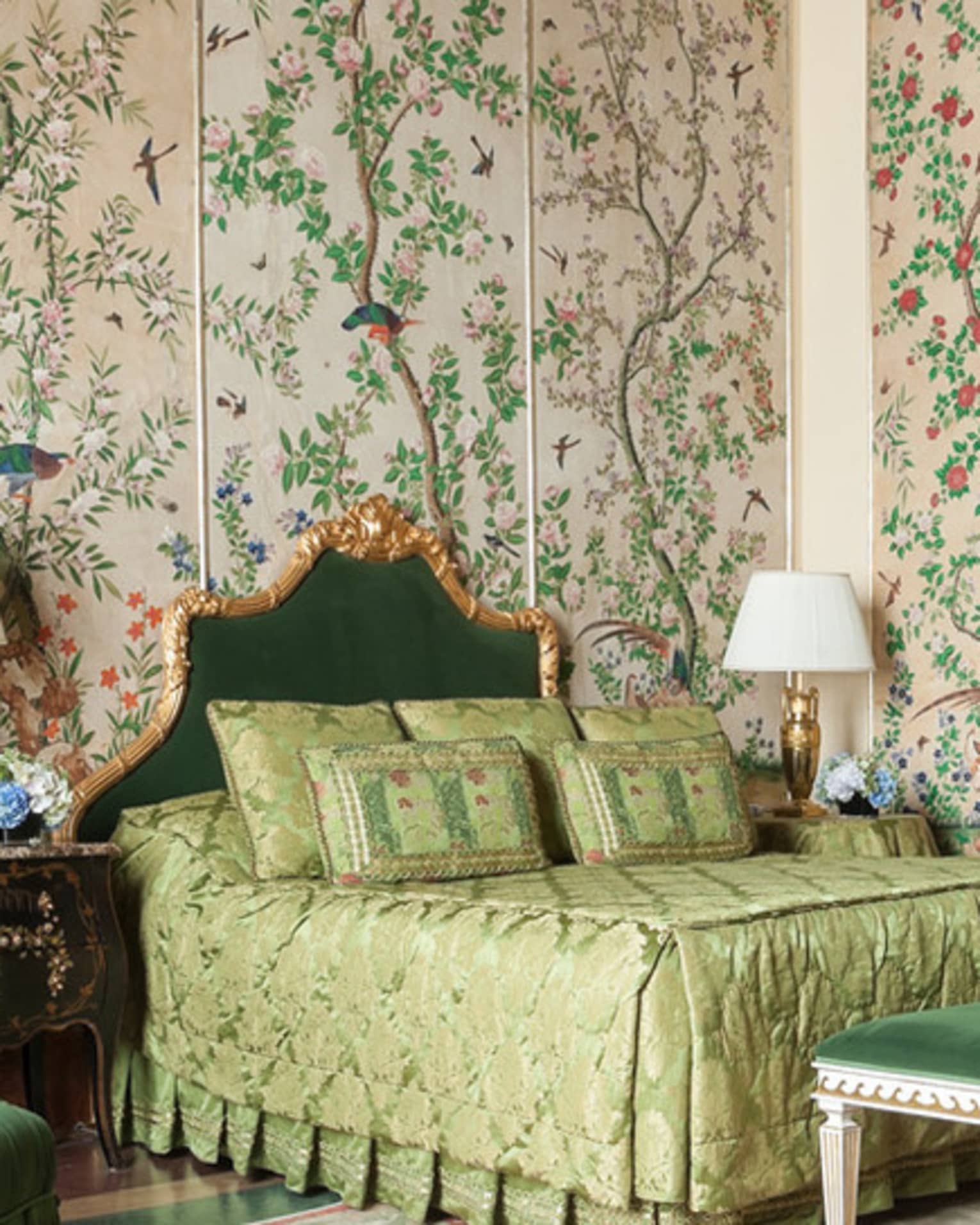 Hotel room with bed, green velvet chair and bench, antique garden wallpaper
