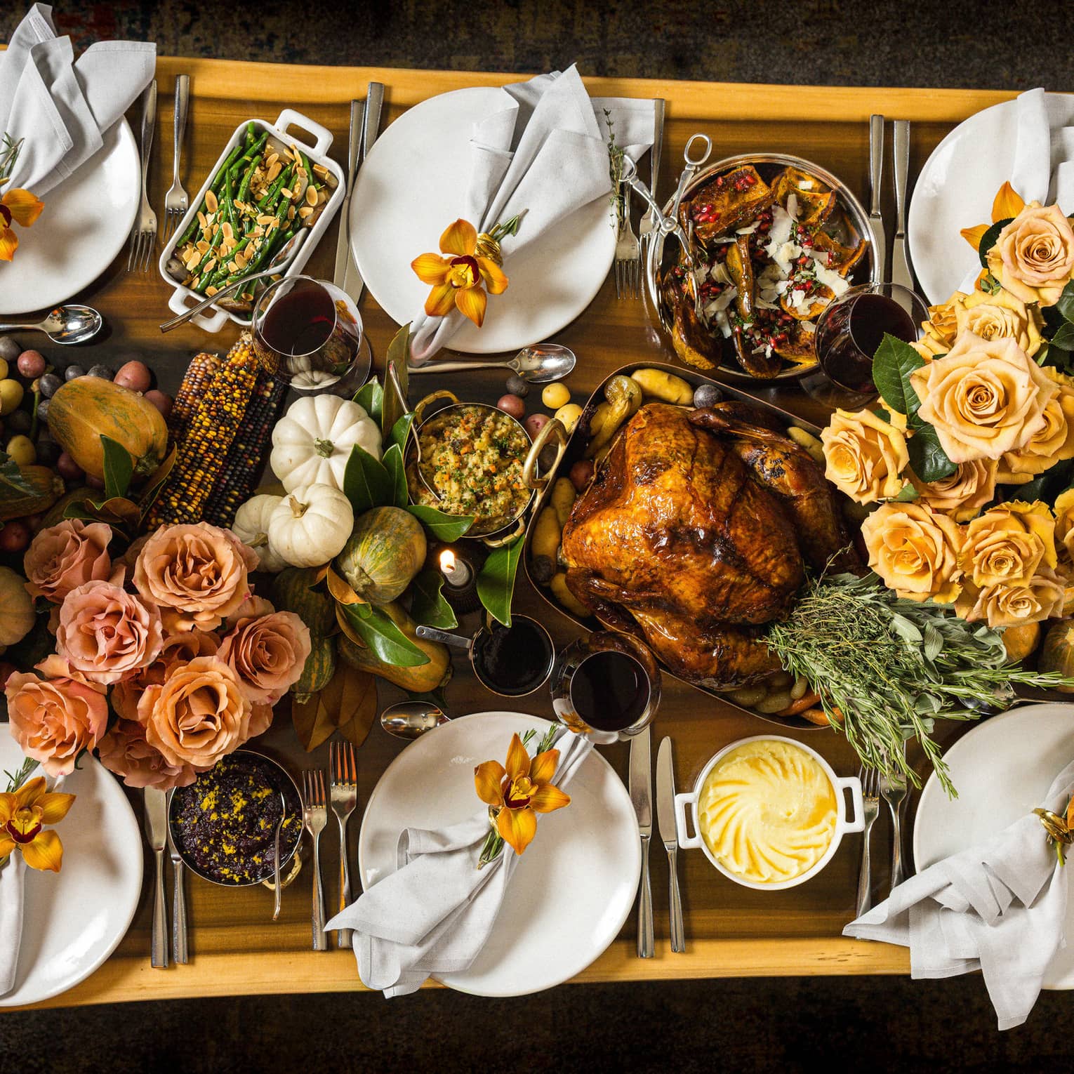 Overhead view of rectangular live-edge wooden table filled with a holiday feast
