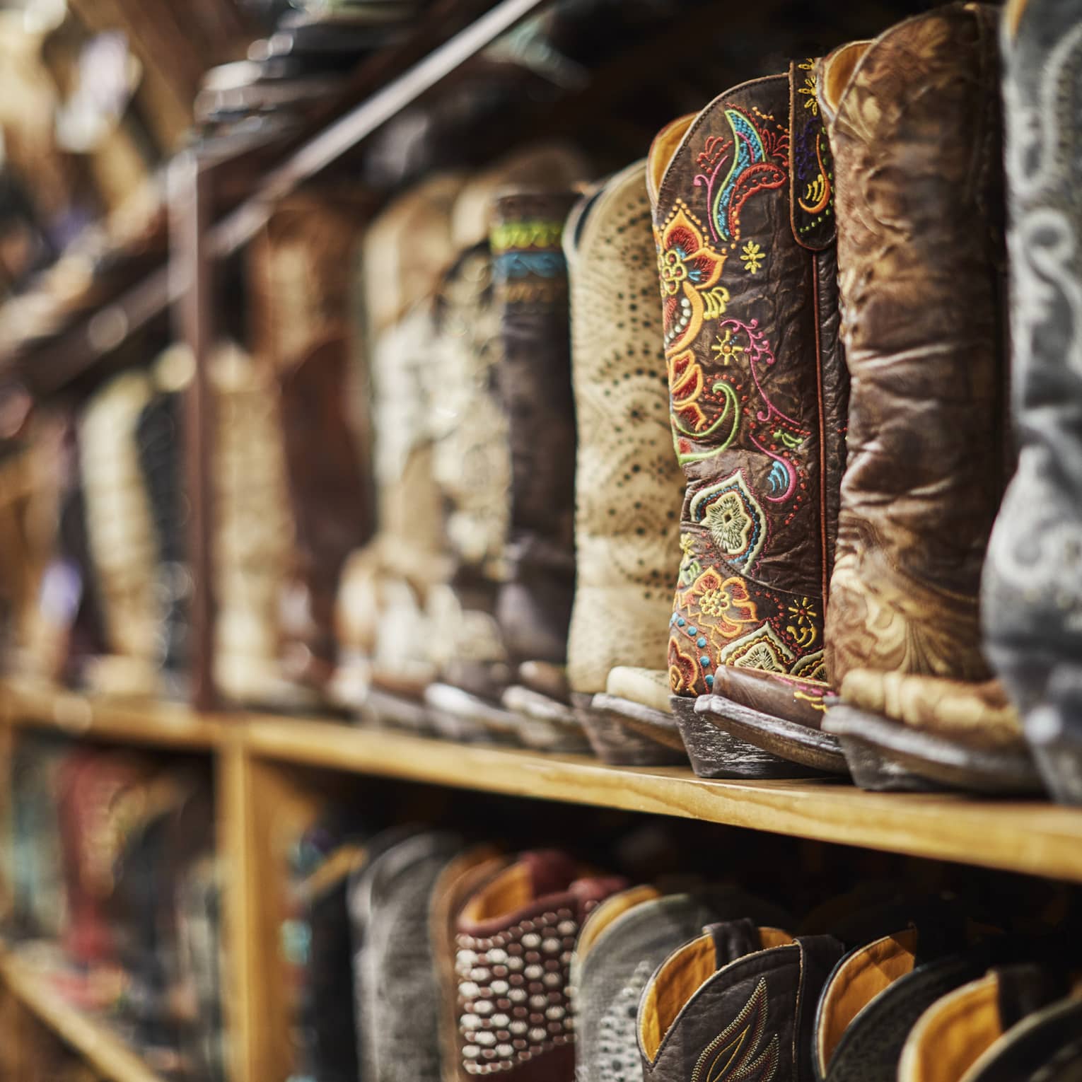 Shelves of cowboy boots of varying colours including black, brown and beige.