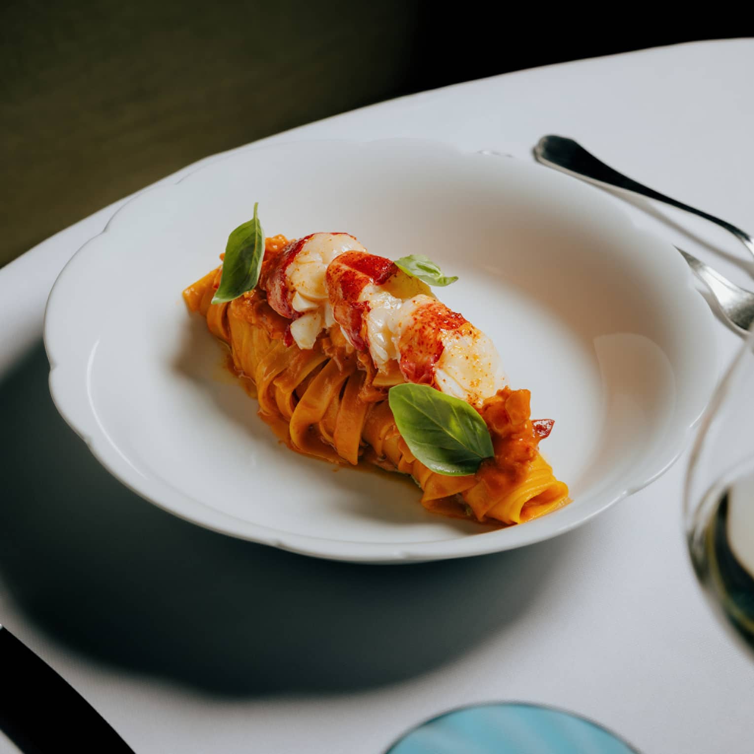 Tagliatelle, Maine lobster and Trapanese pesto served in a white bowl