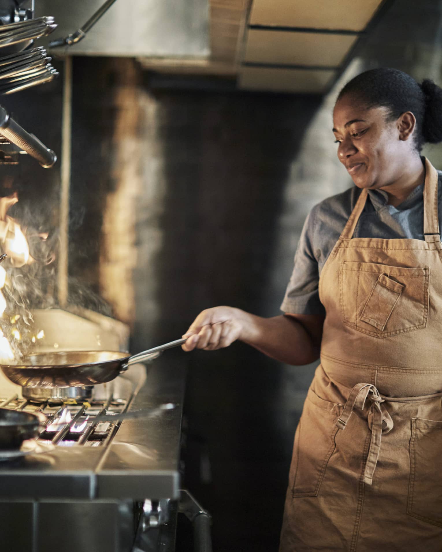 This image depicts a person cooking at the Four Seasons Resort Nevis, West Indies, home to many great ESG initiatives.
