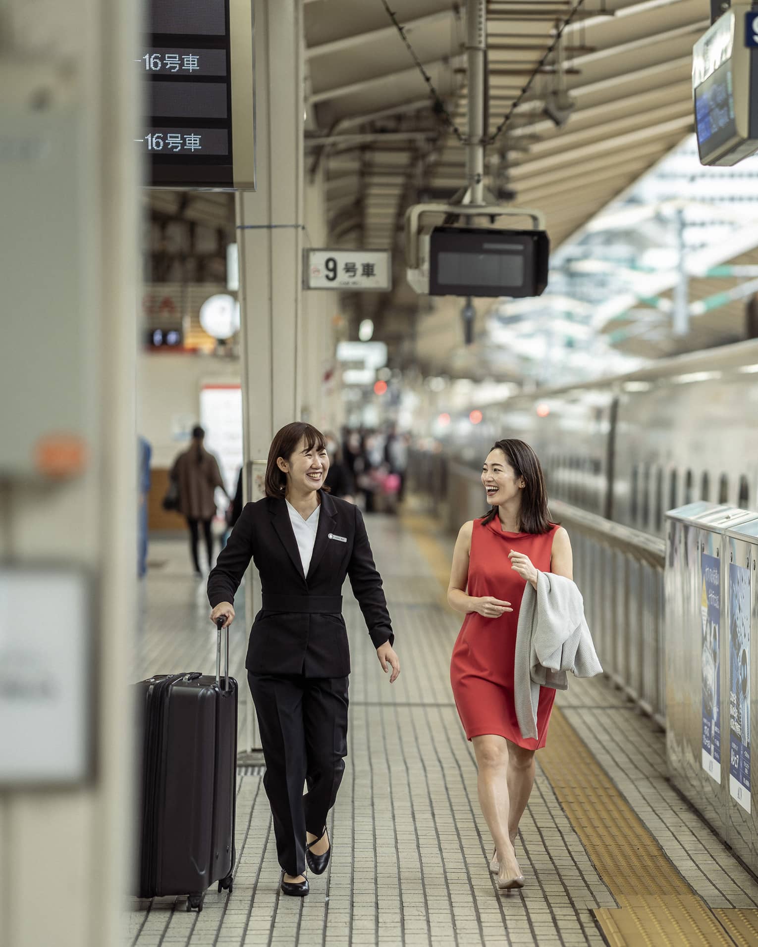Train station greeter walks with female guest along the train platform