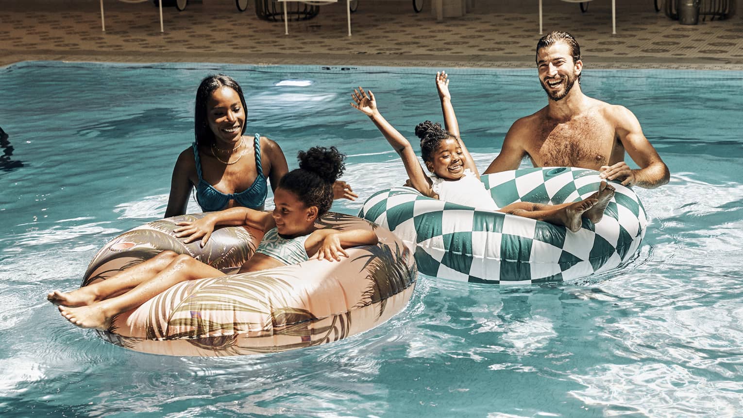 A family in a pool with round tubes.