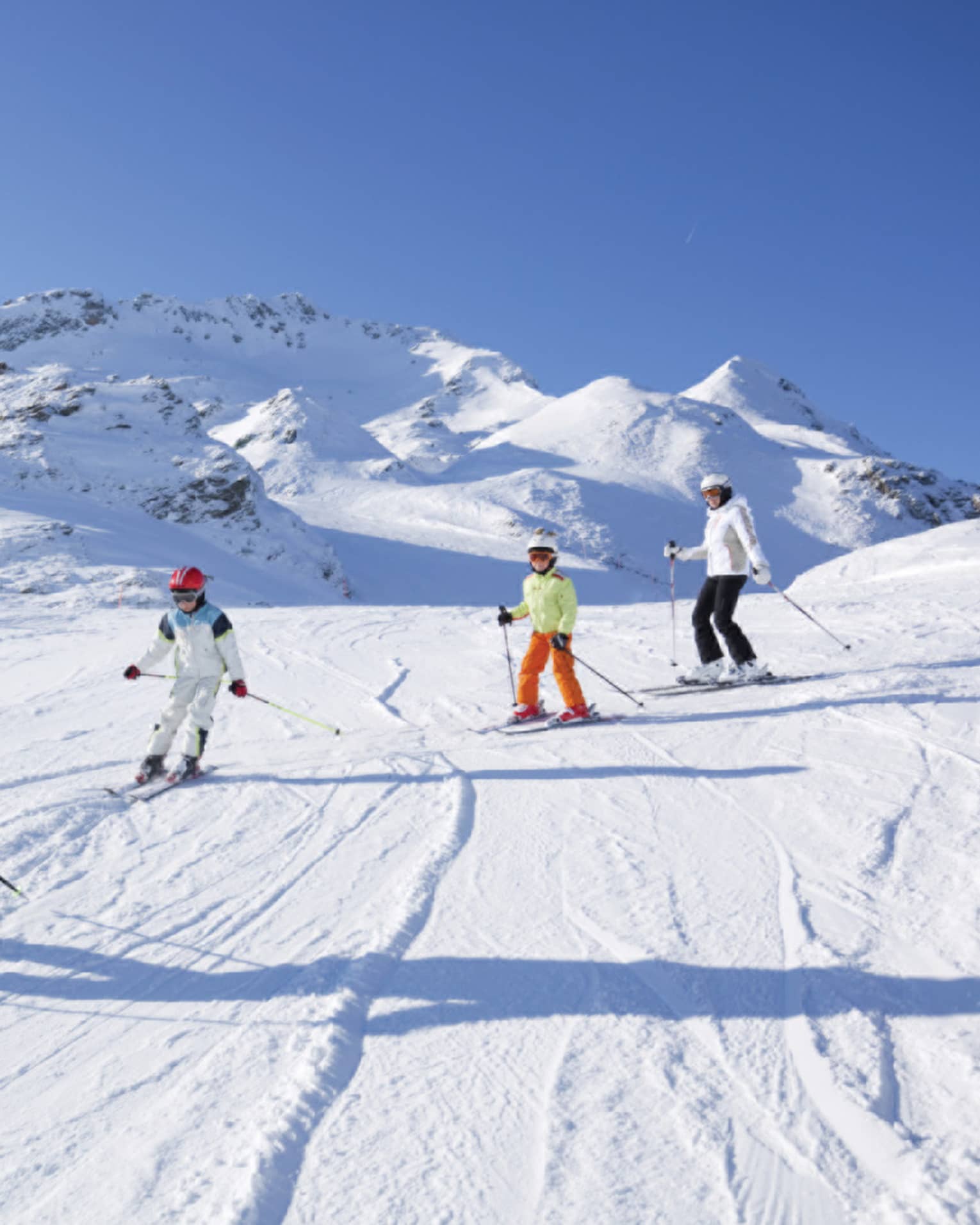 Family skis down snowy mountain