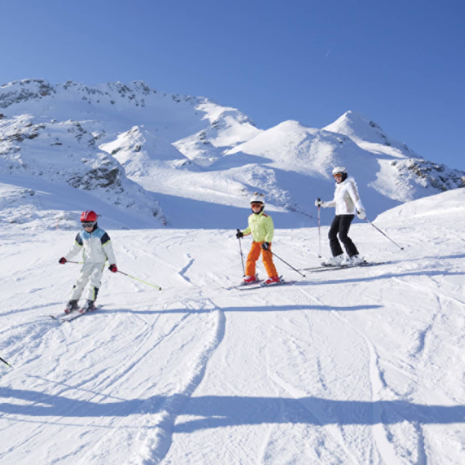 Family skis down snowy mountain