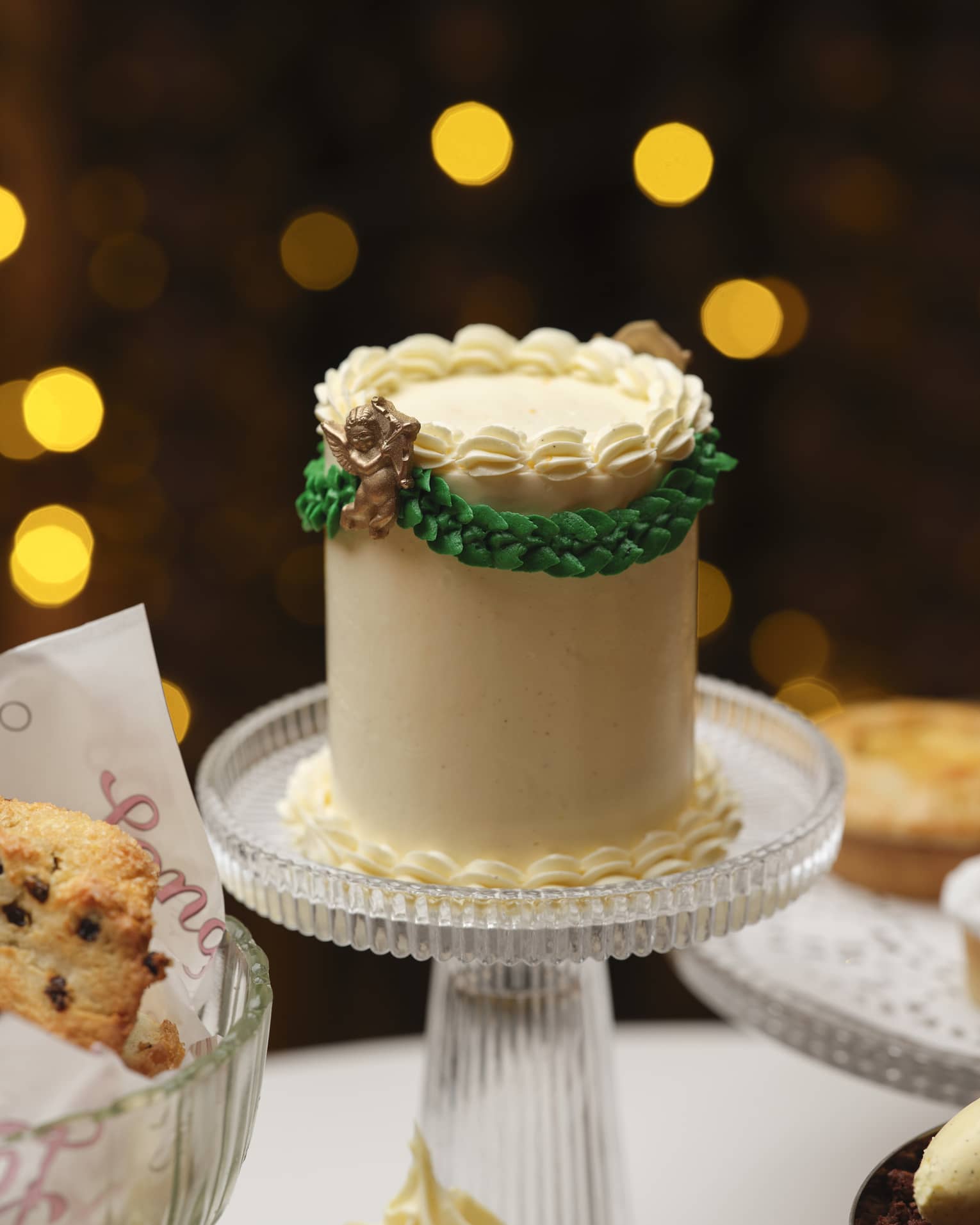 A cake stand and serving dishes bearing cakes and other baked goods