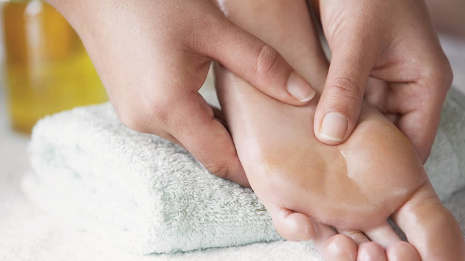 Close-up of hands massaging pressure points on feet