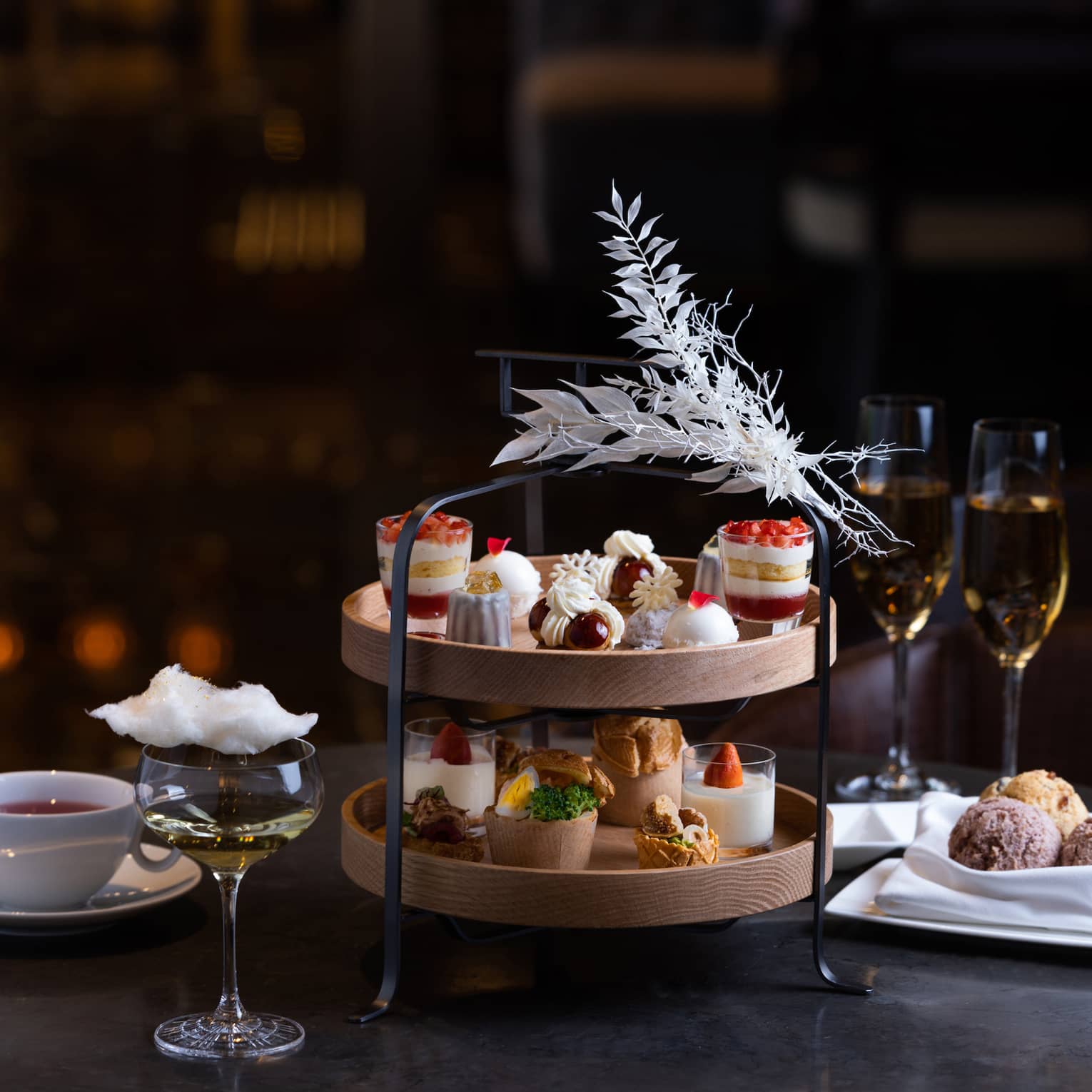 White Christmas Afternoon Tea two-tier display with sweets, two glasses of champagne and coffee