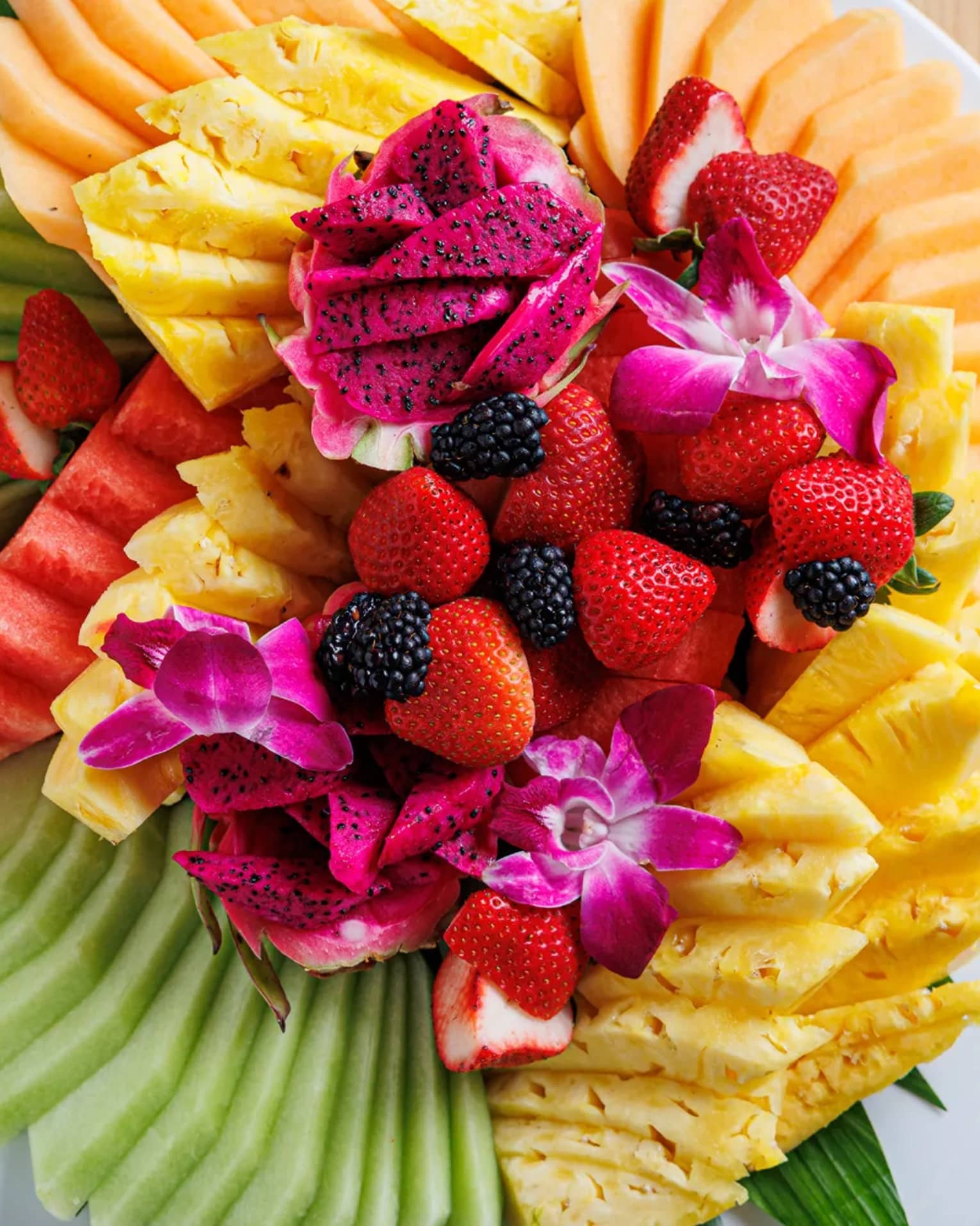 Plate of many different vibrantly colourful fruits