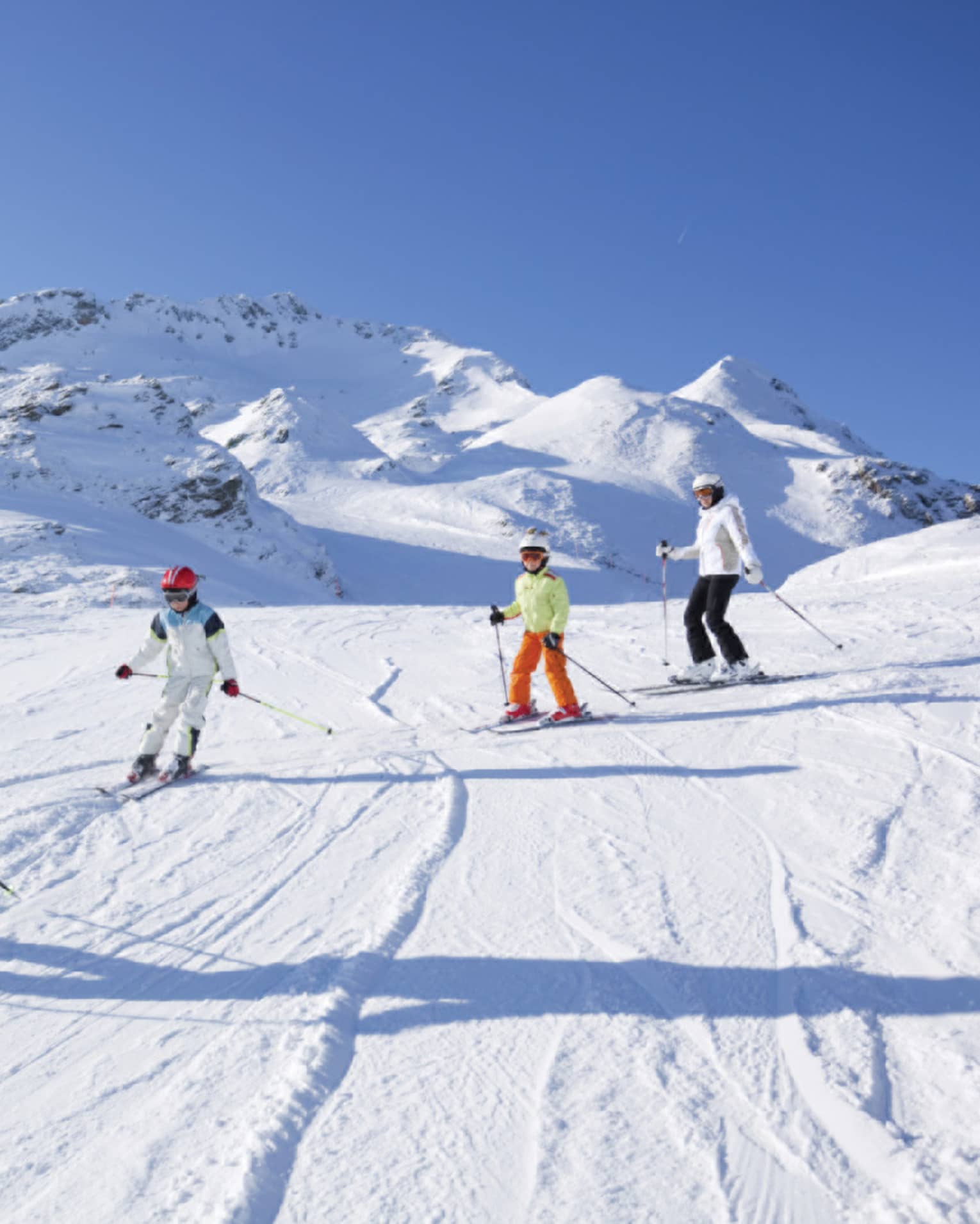 Family skis down snowy mountain