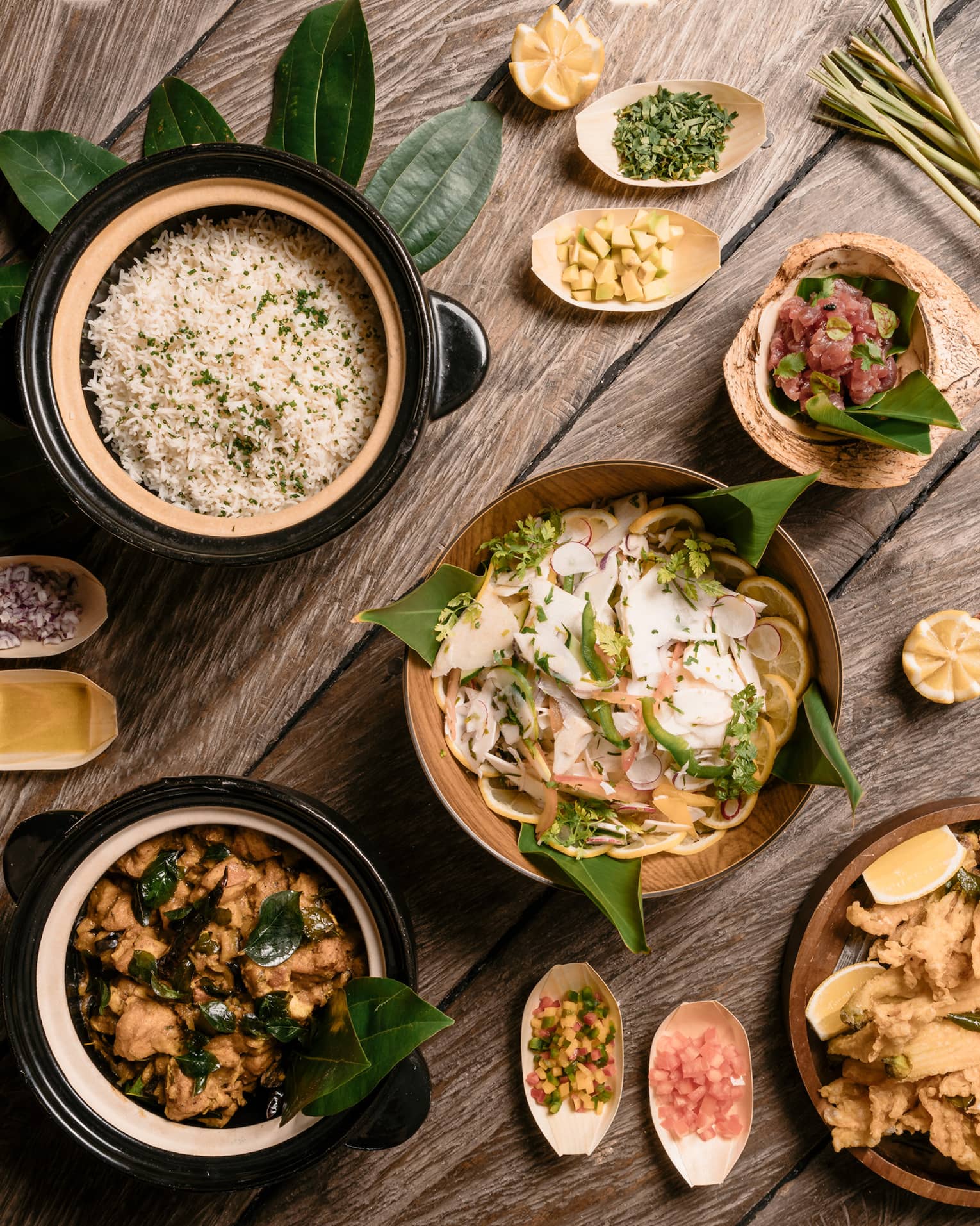 Aerial view of rustic wood table with bowls of gourmet rice, salads and entrees 