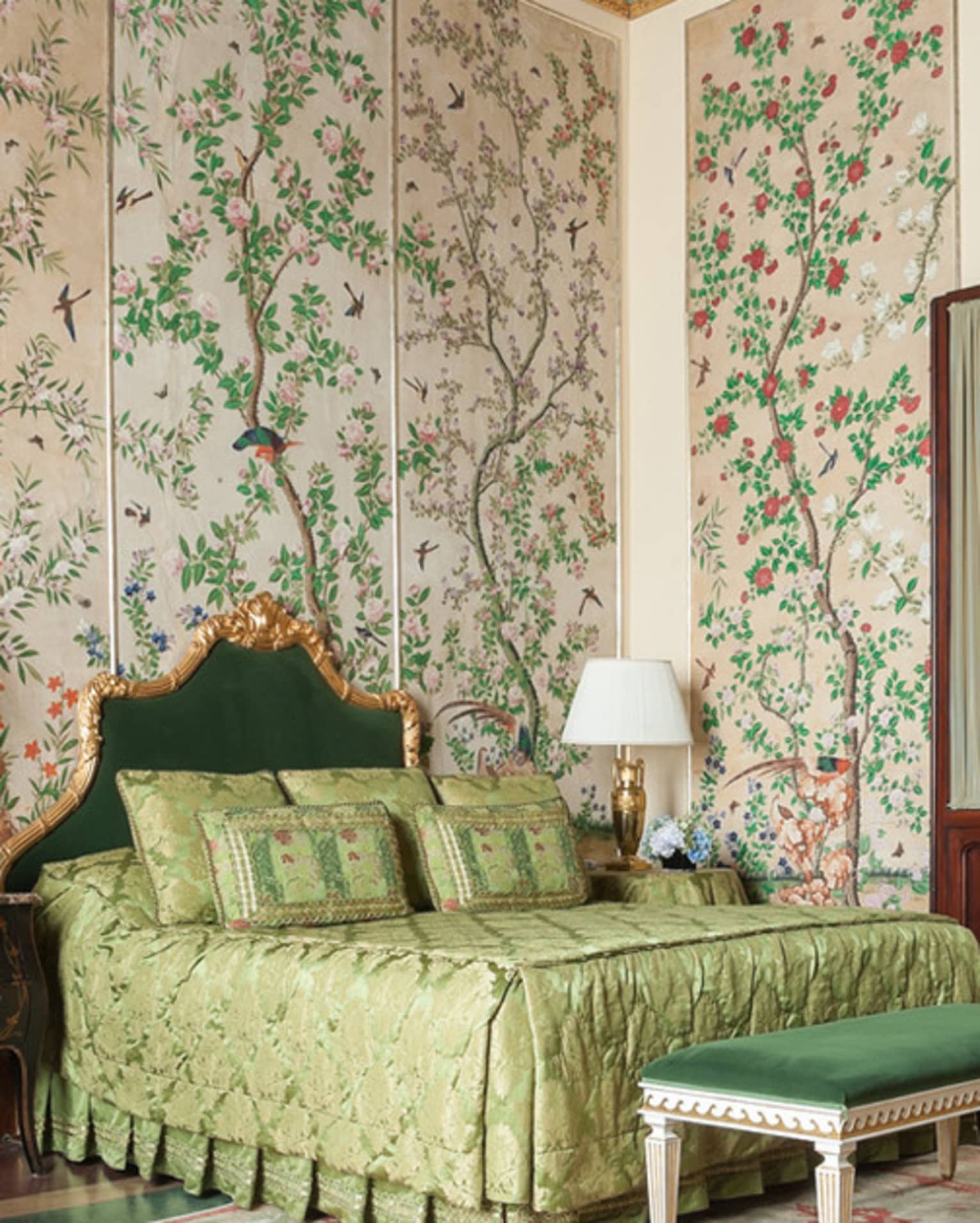 Hotel room with bed, green velvet chair and bench, antique garden wallpaper