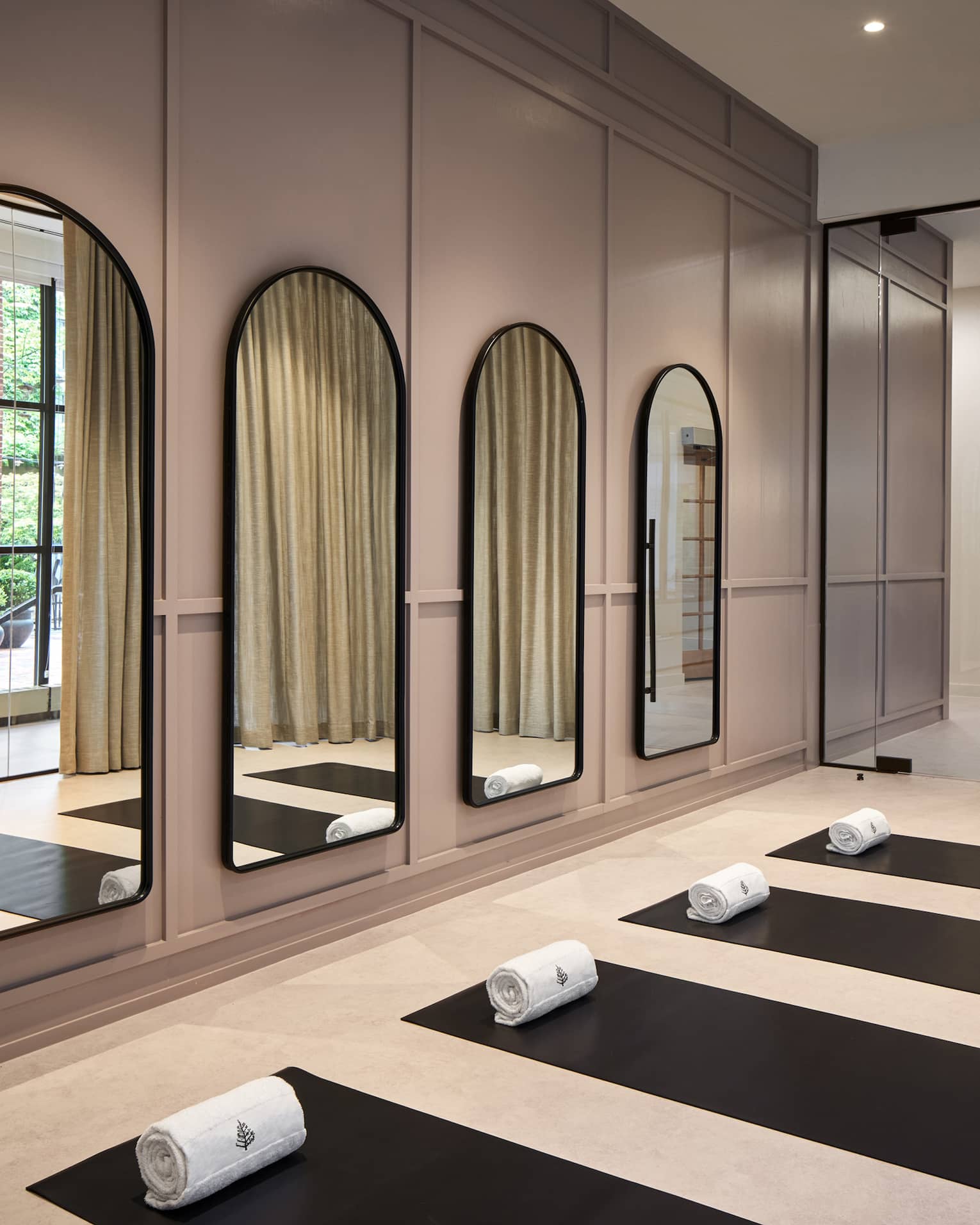 Yoga mats in a yoga studio with mirrors on the wall.