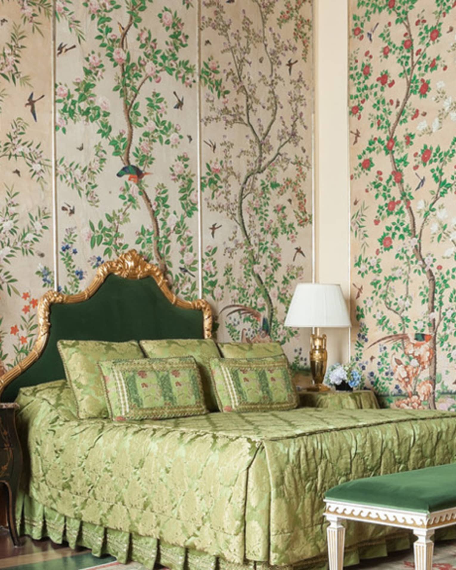 Hotel room with bed, green velvet chair and bench, antique garden wallpaper