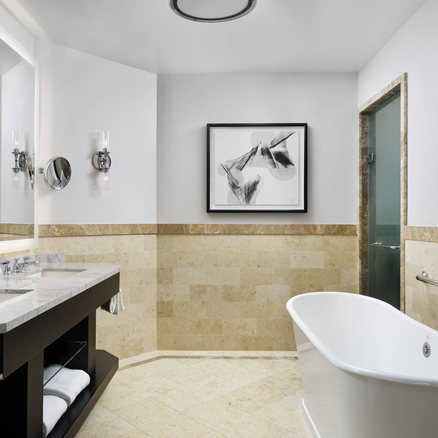 Double marbled vanity with two sinks, full-width mirror, large soaking tub, tiled wall at chair rail