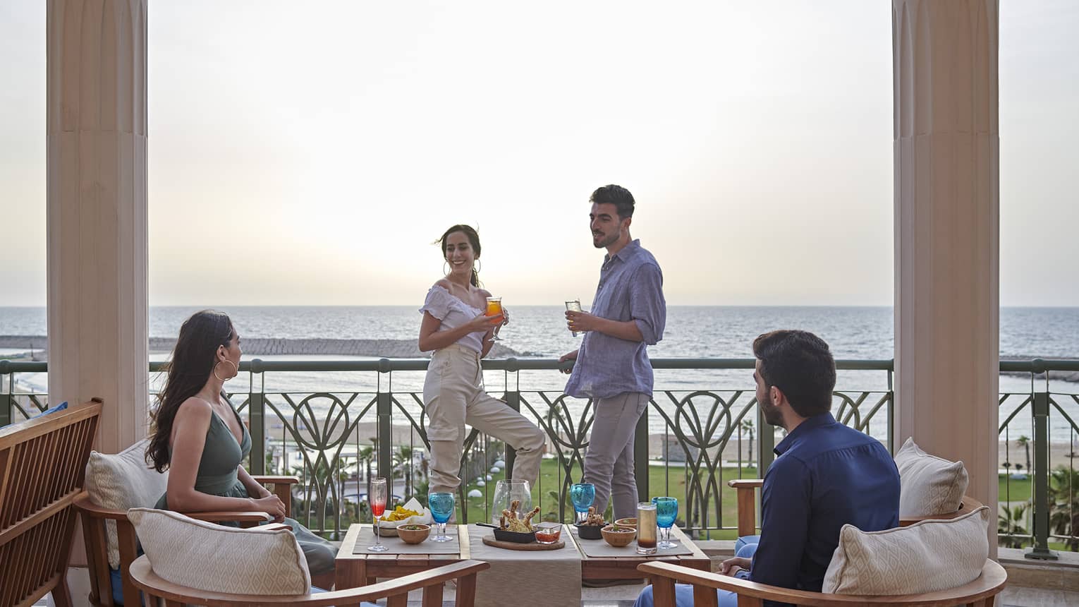 Two couples lounge on a terrace overlooking the ocean at four seasons alexandria