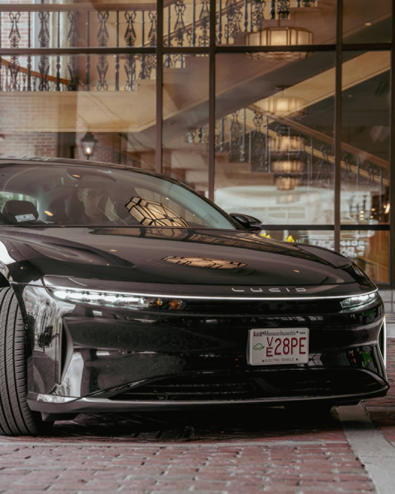Black Lucid car parked outside a hotel on a brick road