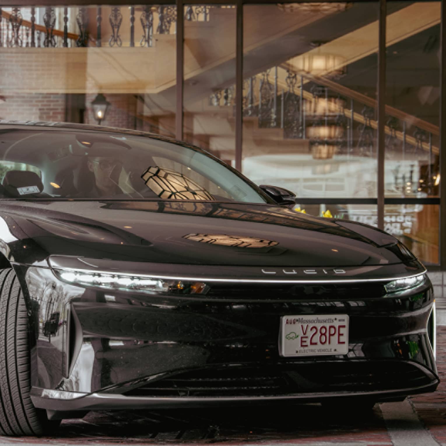 Black Lucid car parked outside a hotel on a brick road