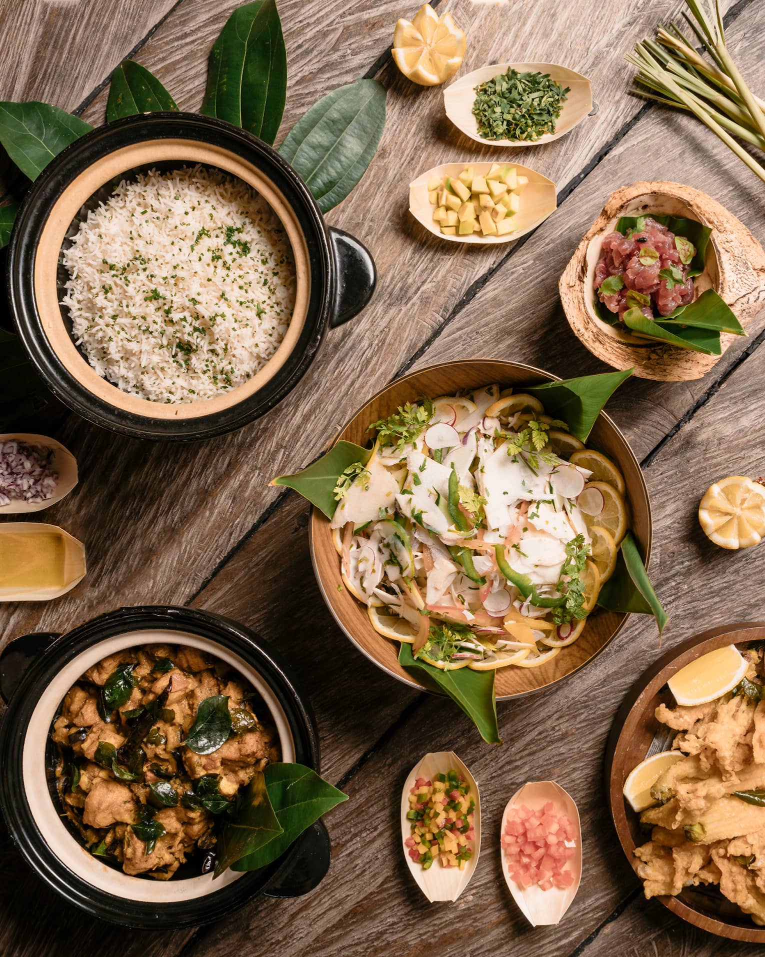 Aerial view of rustic wood table with bowls of gourmet rice, salads and entrees 