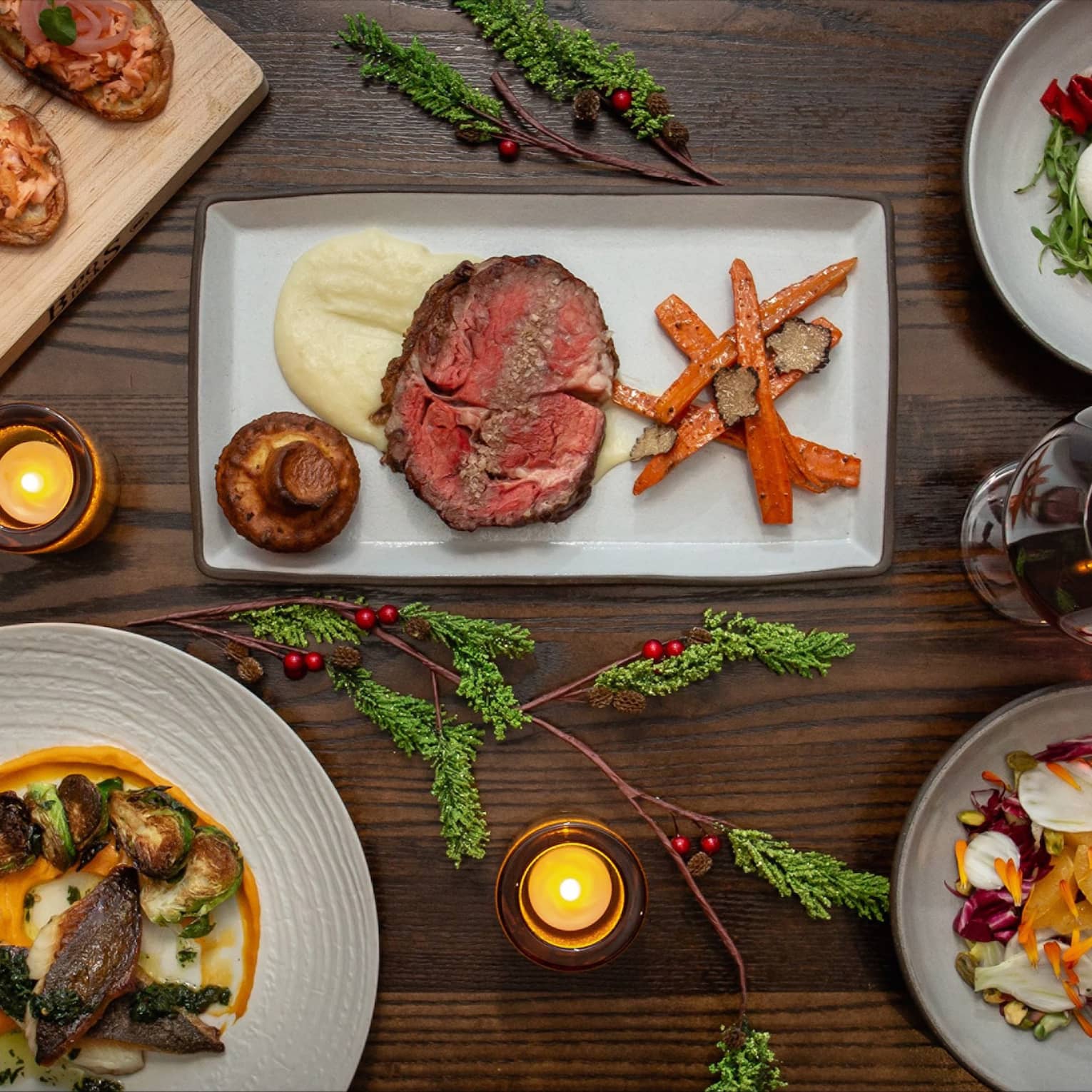 An assortment of holiday food on white and wood trays.