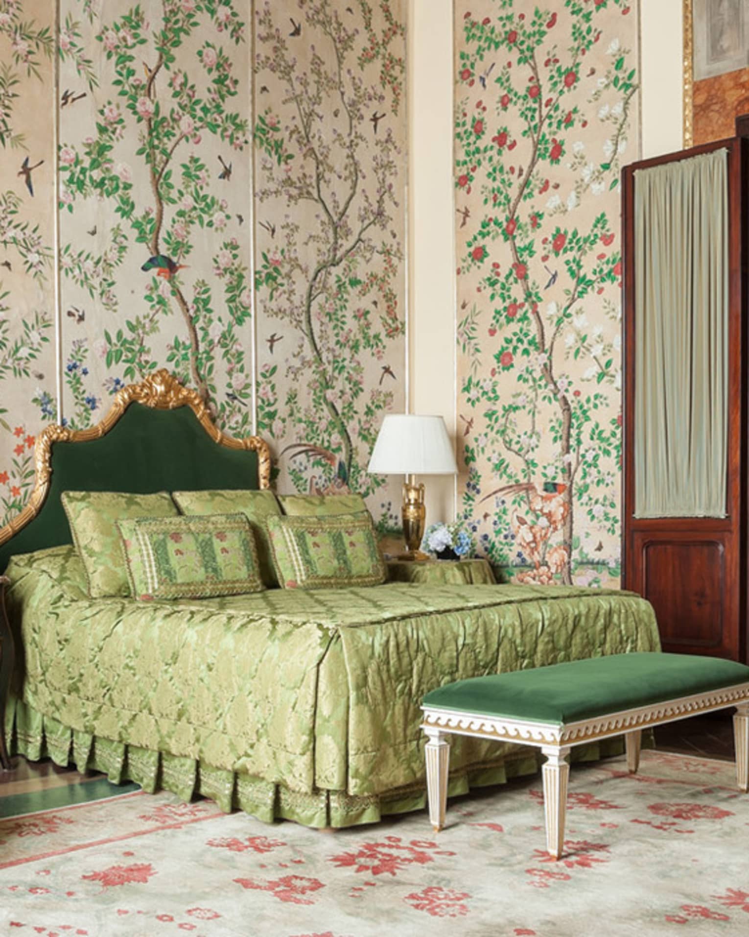 Hotel room with bed, green velvet chair and bench, antique garden wallpaper