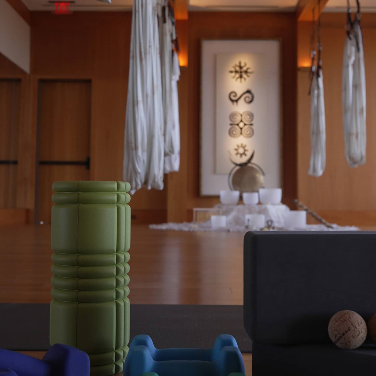 Fitness studio with hanging aerial yoga hammocks weights and a foam roller