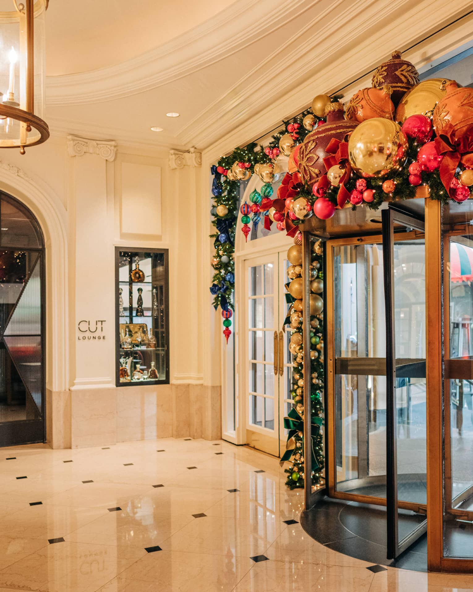 Hotel entrance rotating door decorated with holiday garland and ornaments