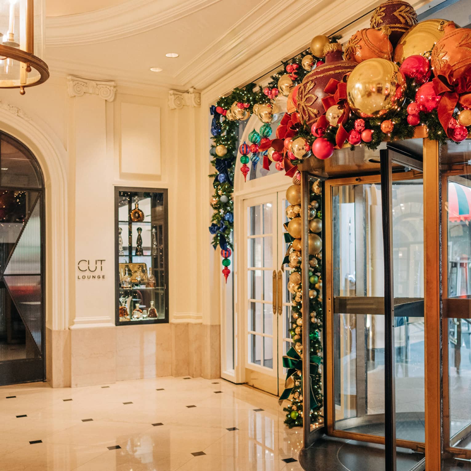 Hotel entrance rotating door decorated with holiday garland and ornaments