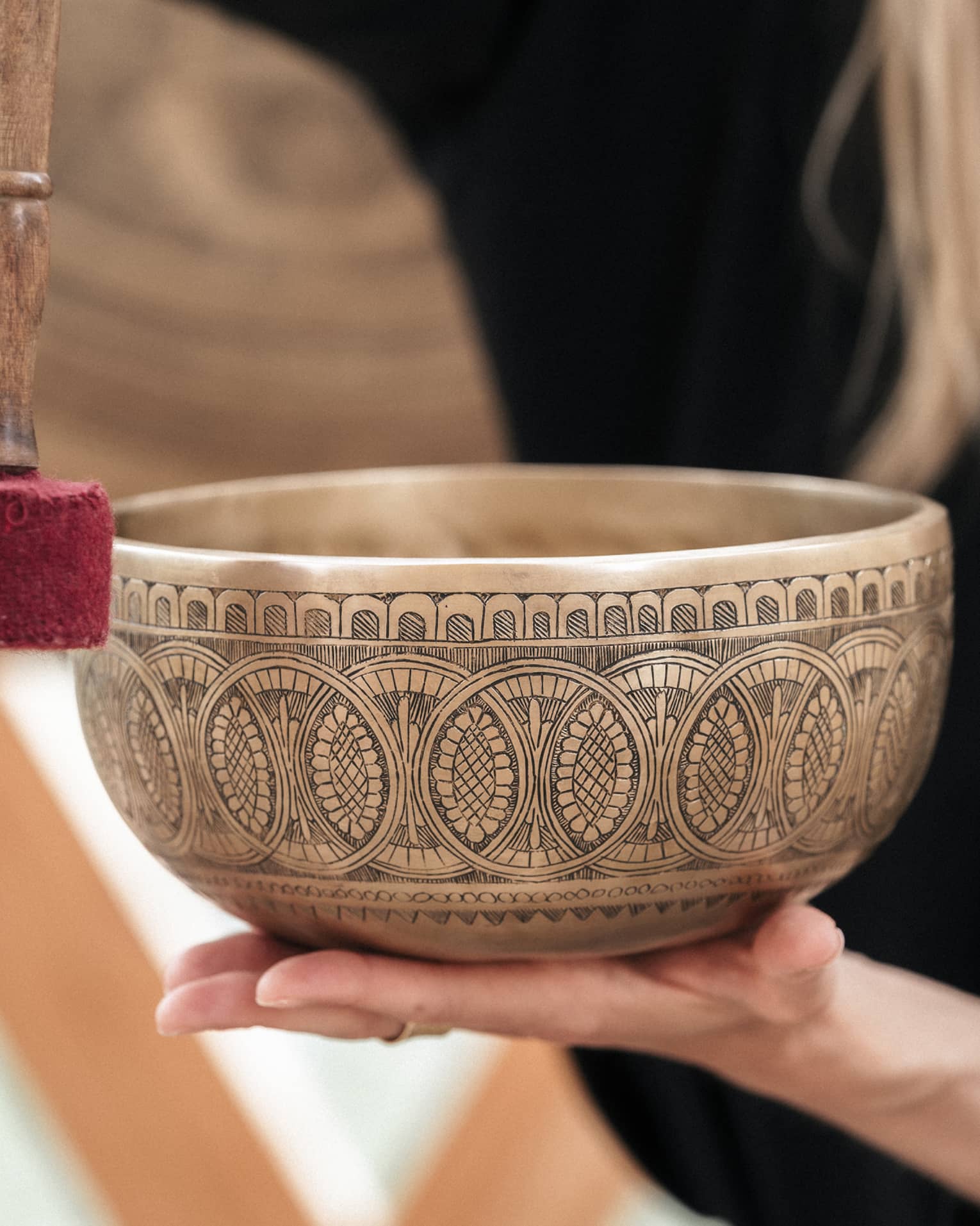 Person holding a gold engraved sound bath healing bowl