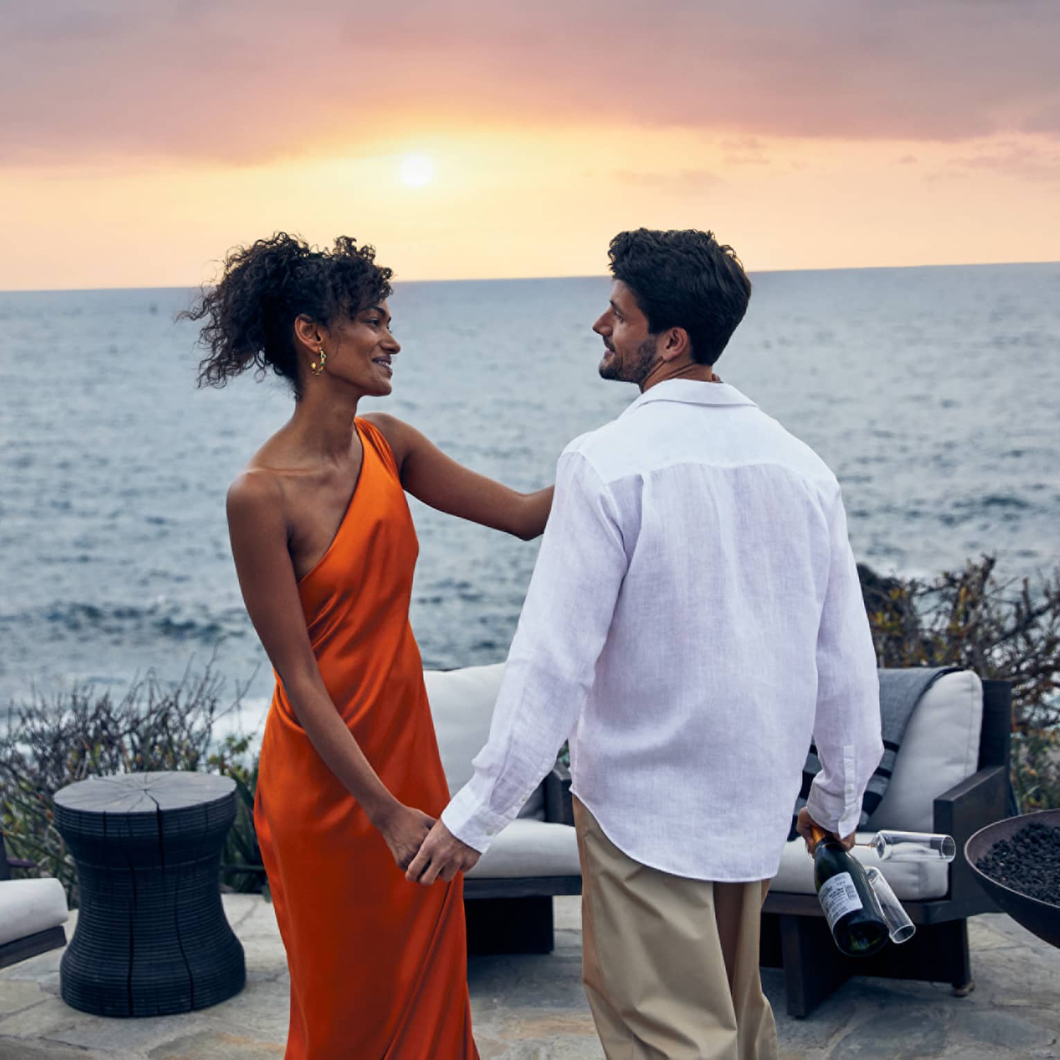 A couple sharing a romantic sunset view over the ocean.