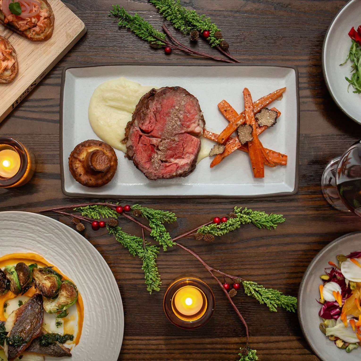 An assortment of holiday food on white and wood trays.