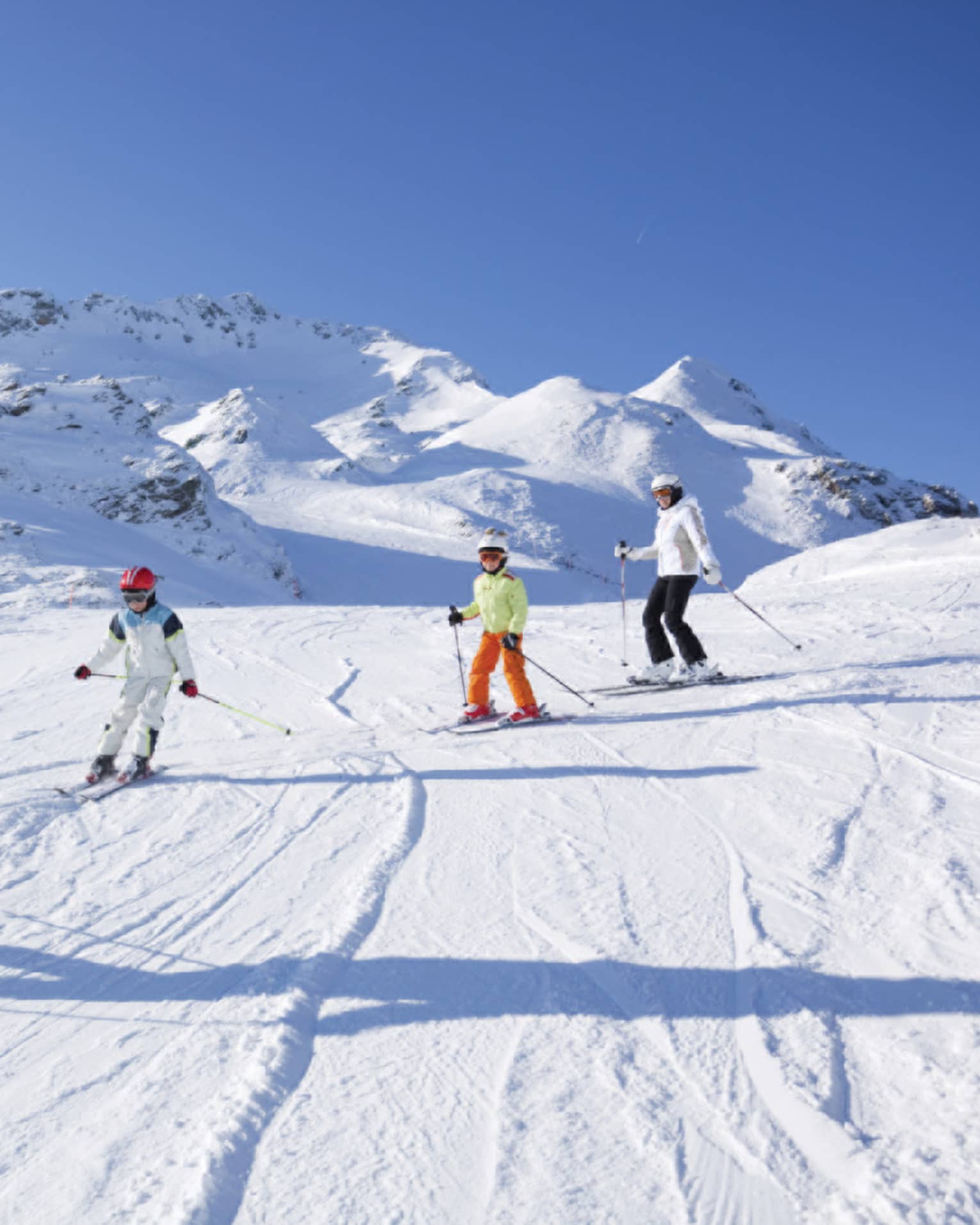 Family skis down snowy mountain