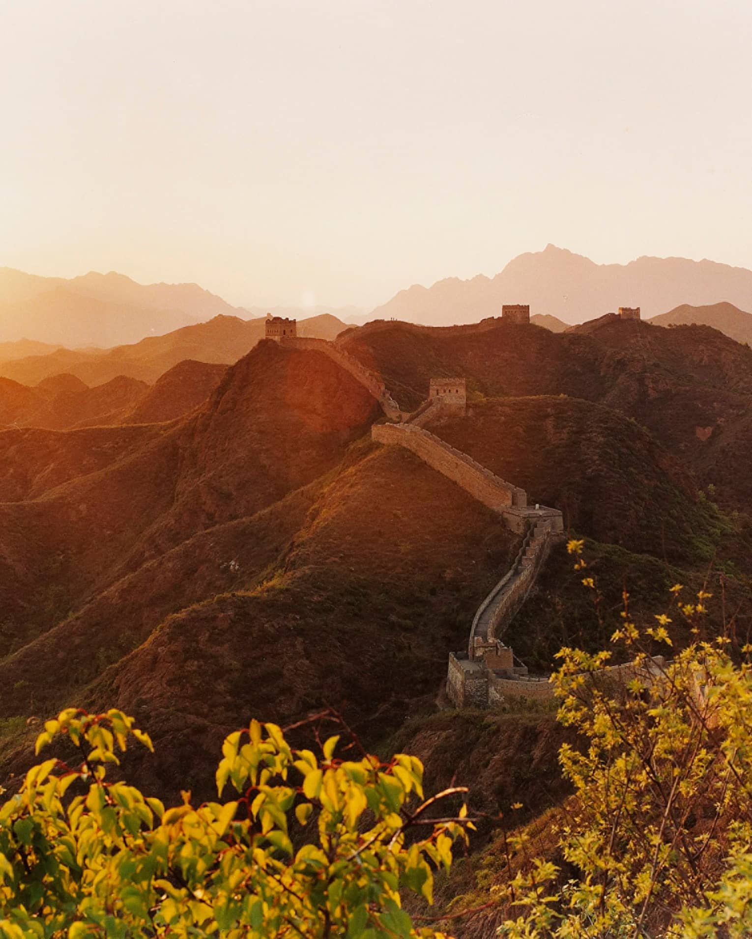 Sunset over mountain, trees with Great Wall of China along side