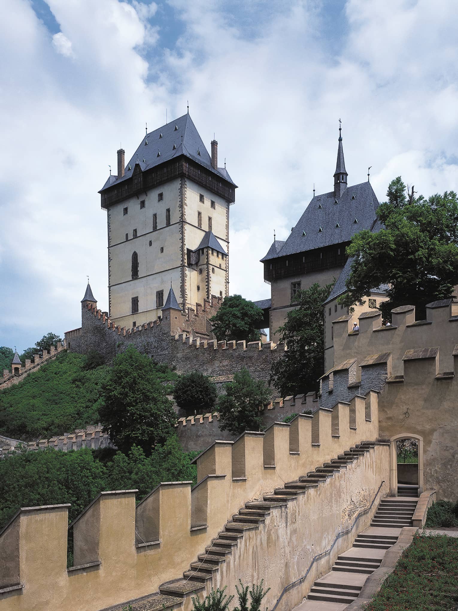 Looking up at historic Prague Karlstejn Castle towers, castle walls on sunny day