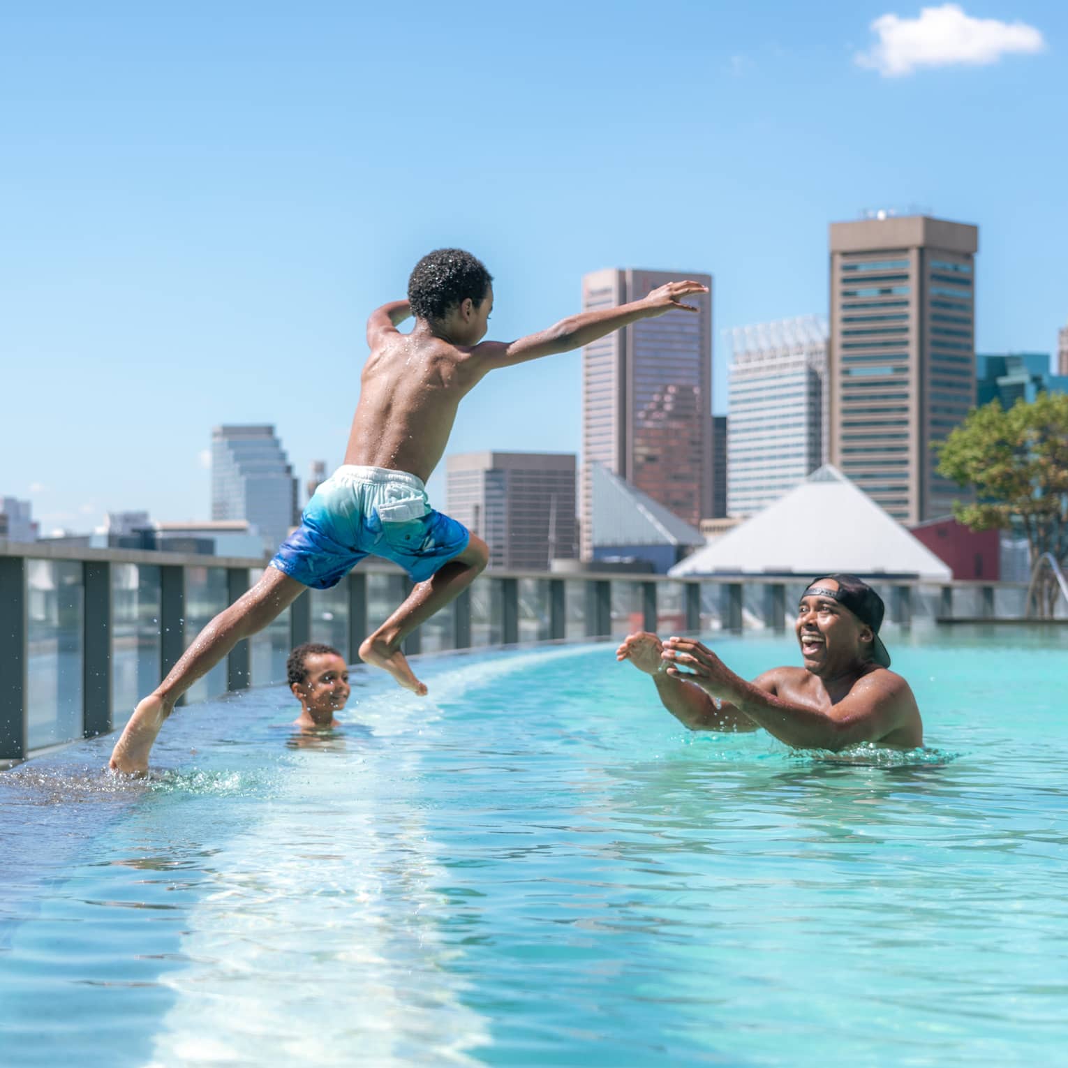 Child jumps into pool as parent waits in the water with open arms