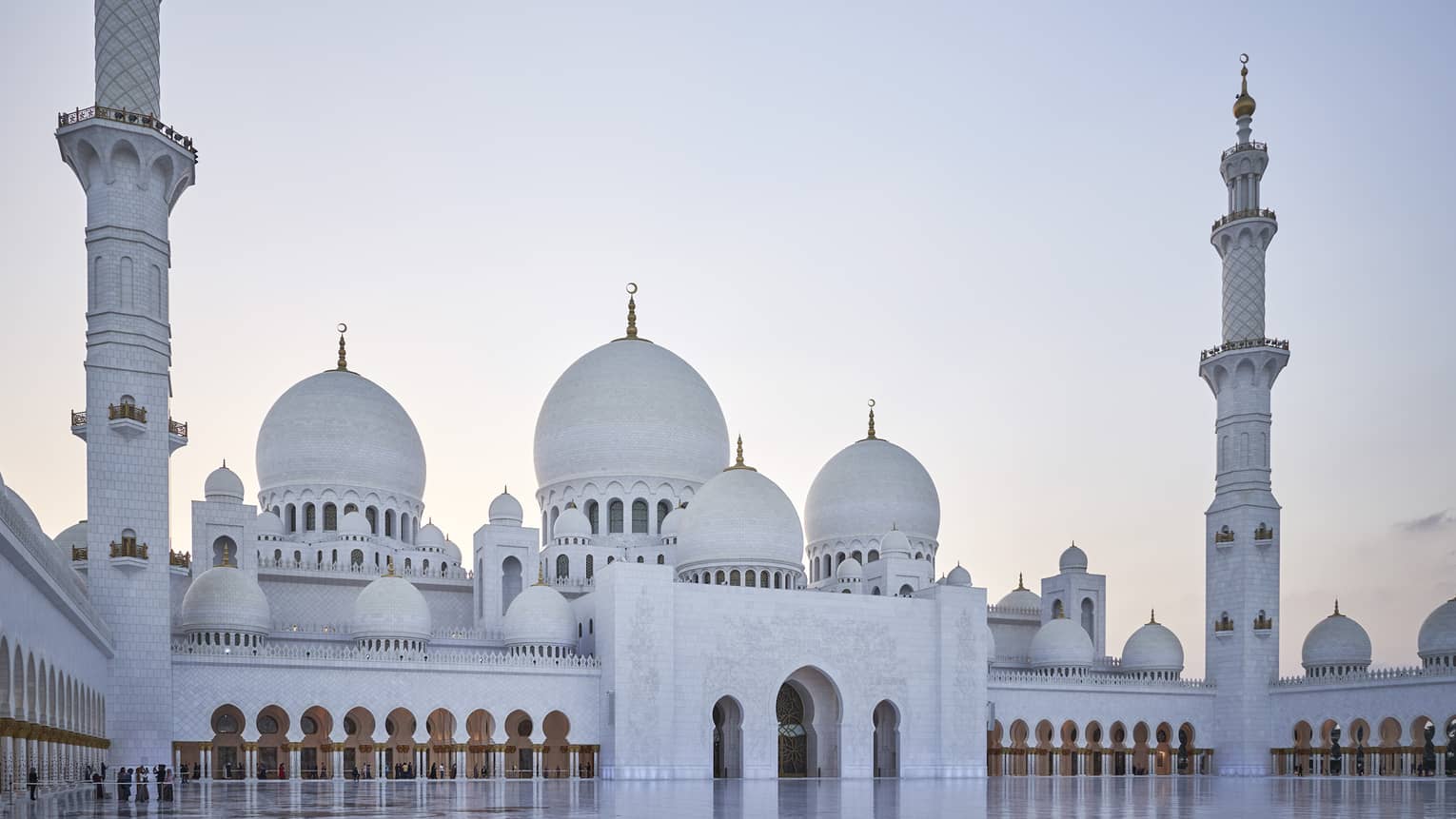 A large white mosque with two pillars made of marble.
