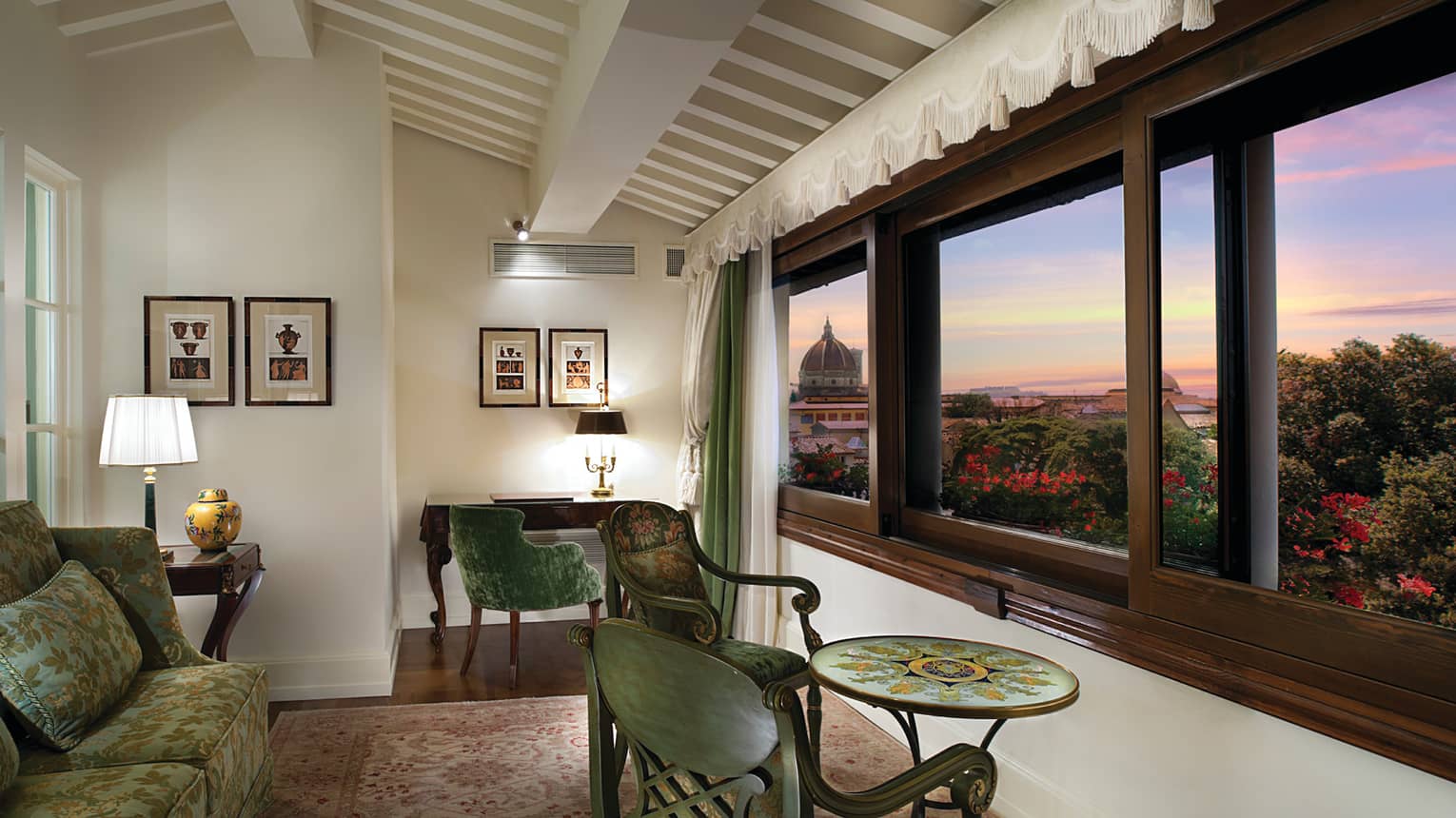 Duomo View Executive Suite green sofas, chairs and table by large picture window overlooking Florence, sunset