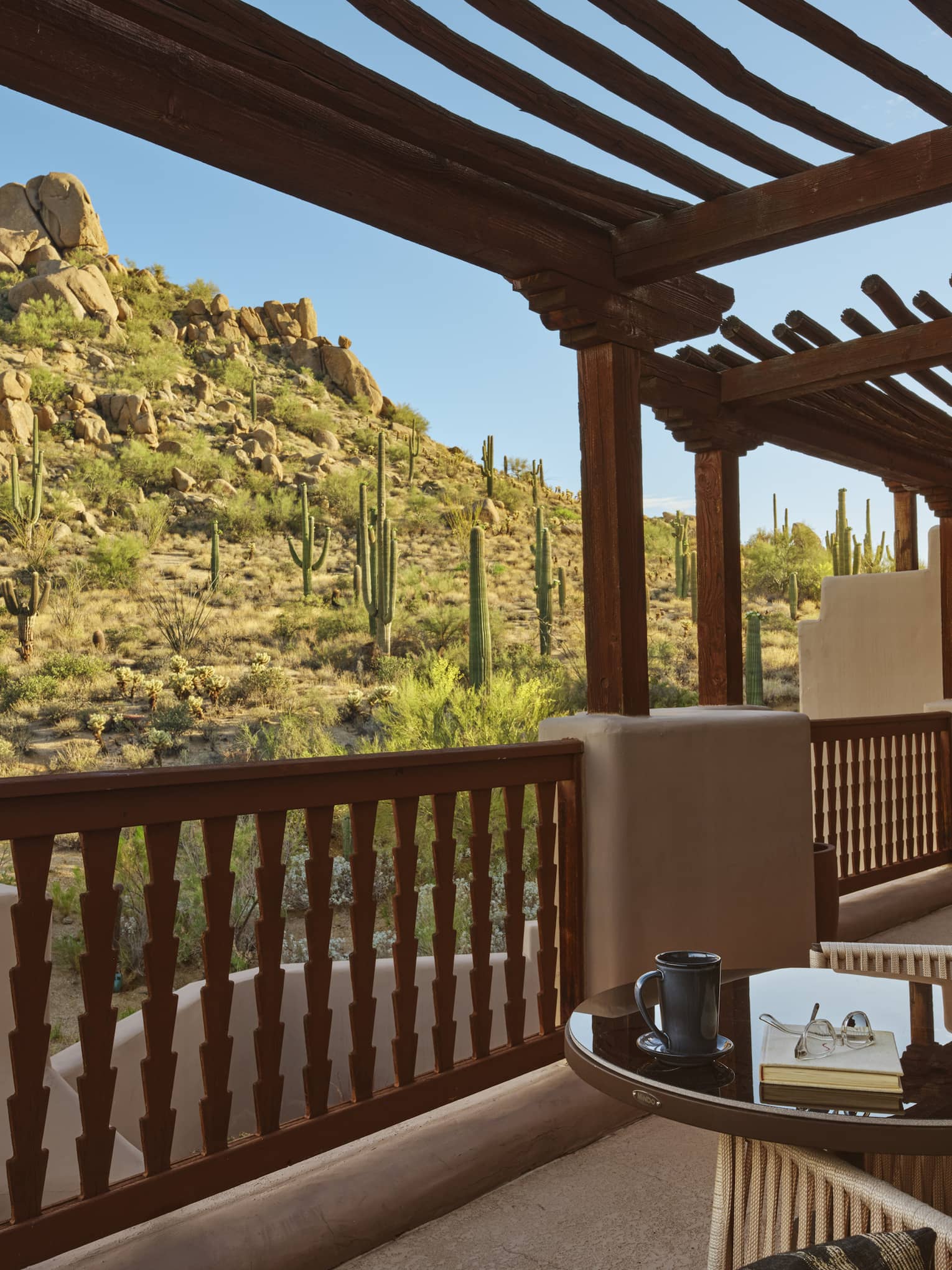 Private terrace with two sets of table and two chairs, with desert mountain view