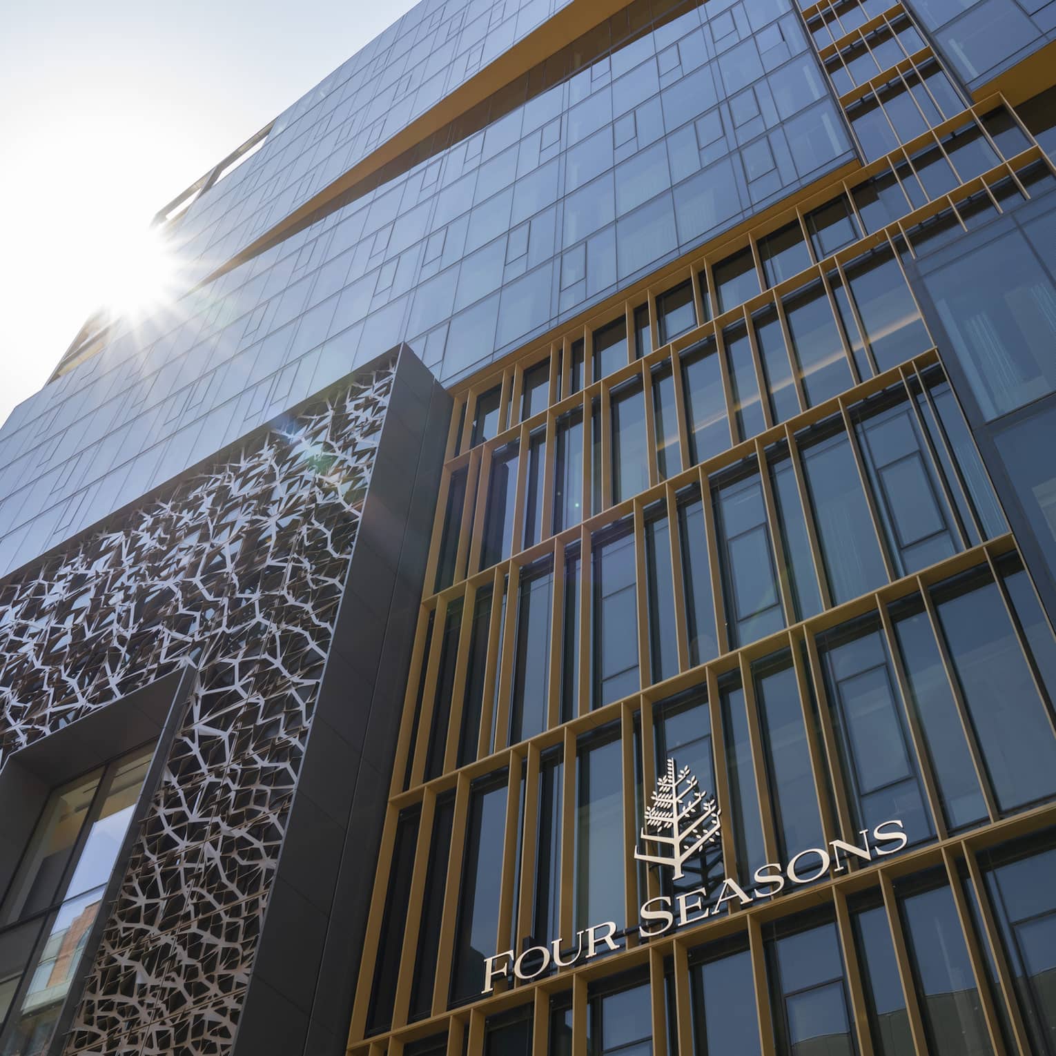 A front view of the Four Seasons Montreal hotel, featuring the Art Deco design above the entrance. 