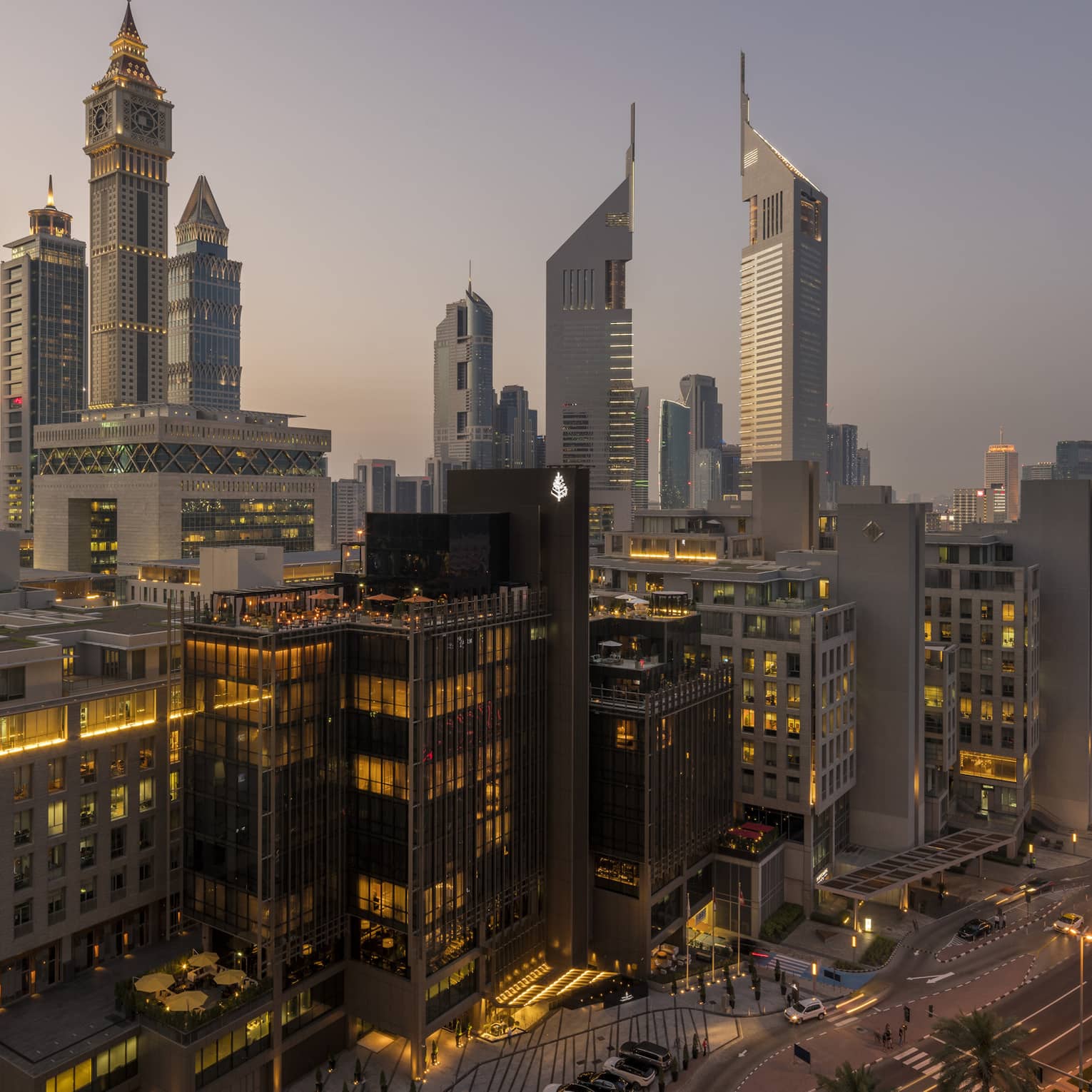 Aerial view of Dubai city skyline, road, lights around Four Seasons International Financial Centre hotel at sunset