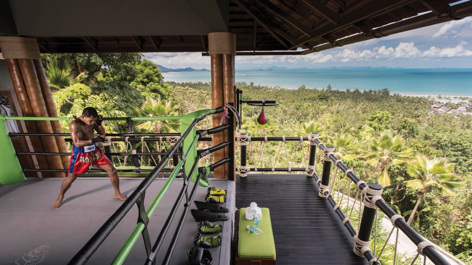 Boxer practices in Muay Thai boxing ring high up in mountain