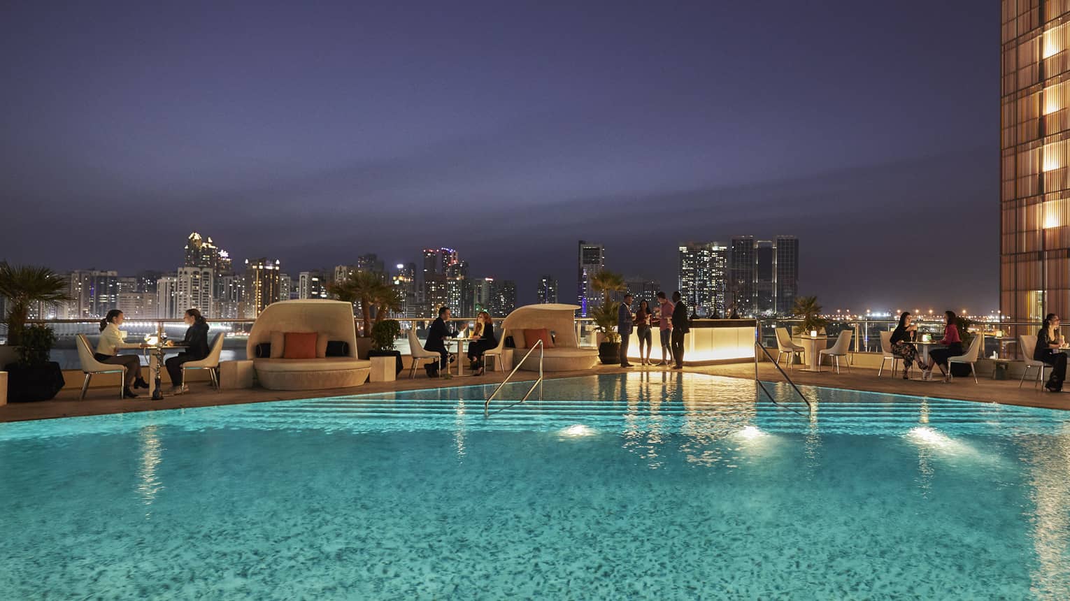 People gather around Eclipse pool at night 