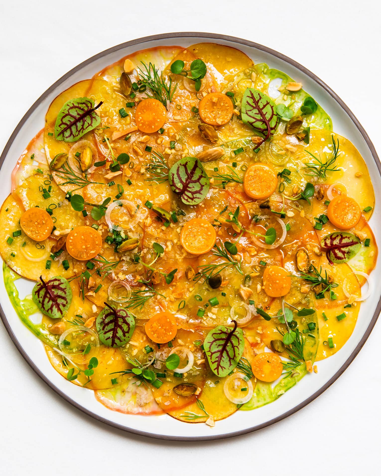 Sicilian pistachios, chives and ginger vinaigrette on a white plate.