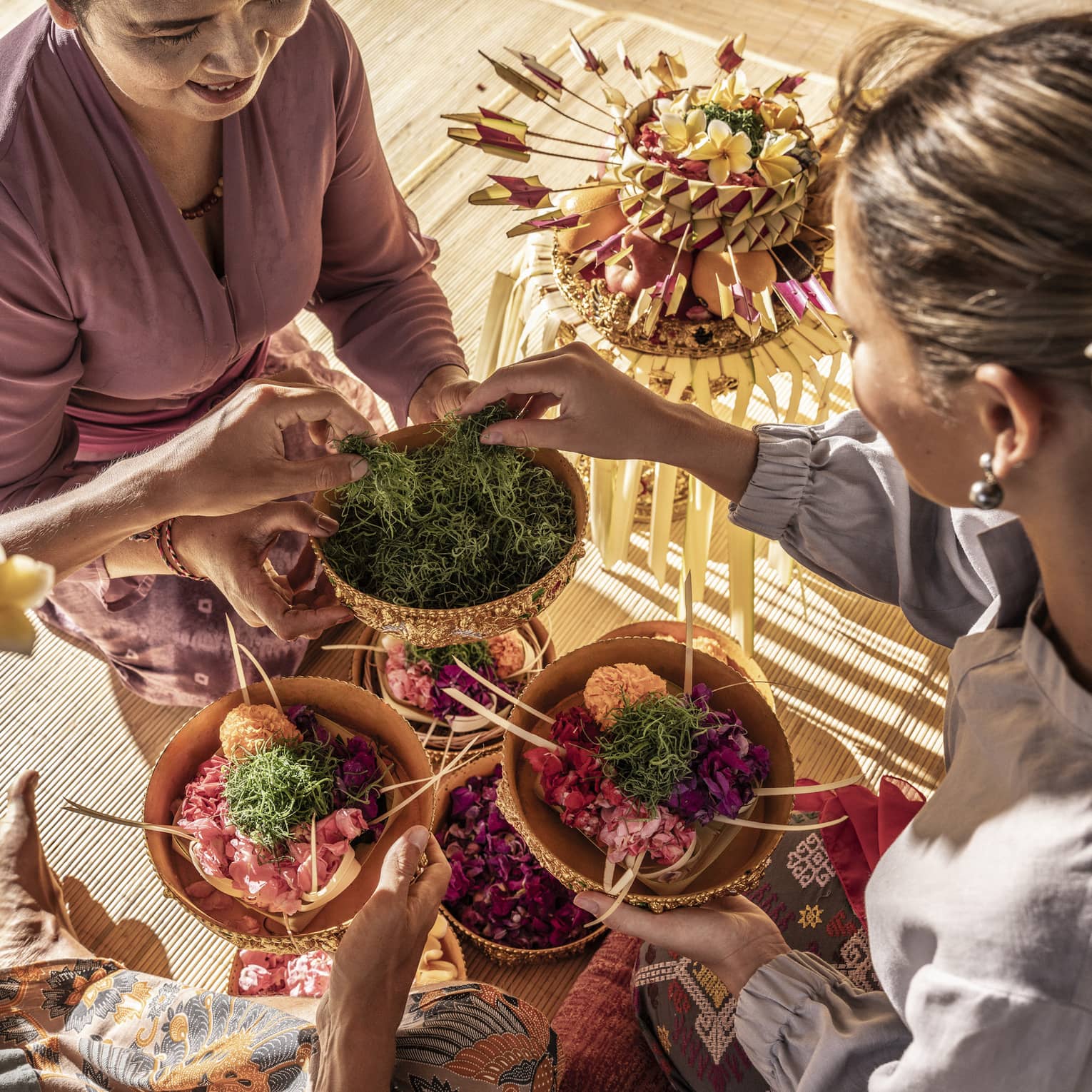 Two guests select green moss from bowl to top their own colourful creations