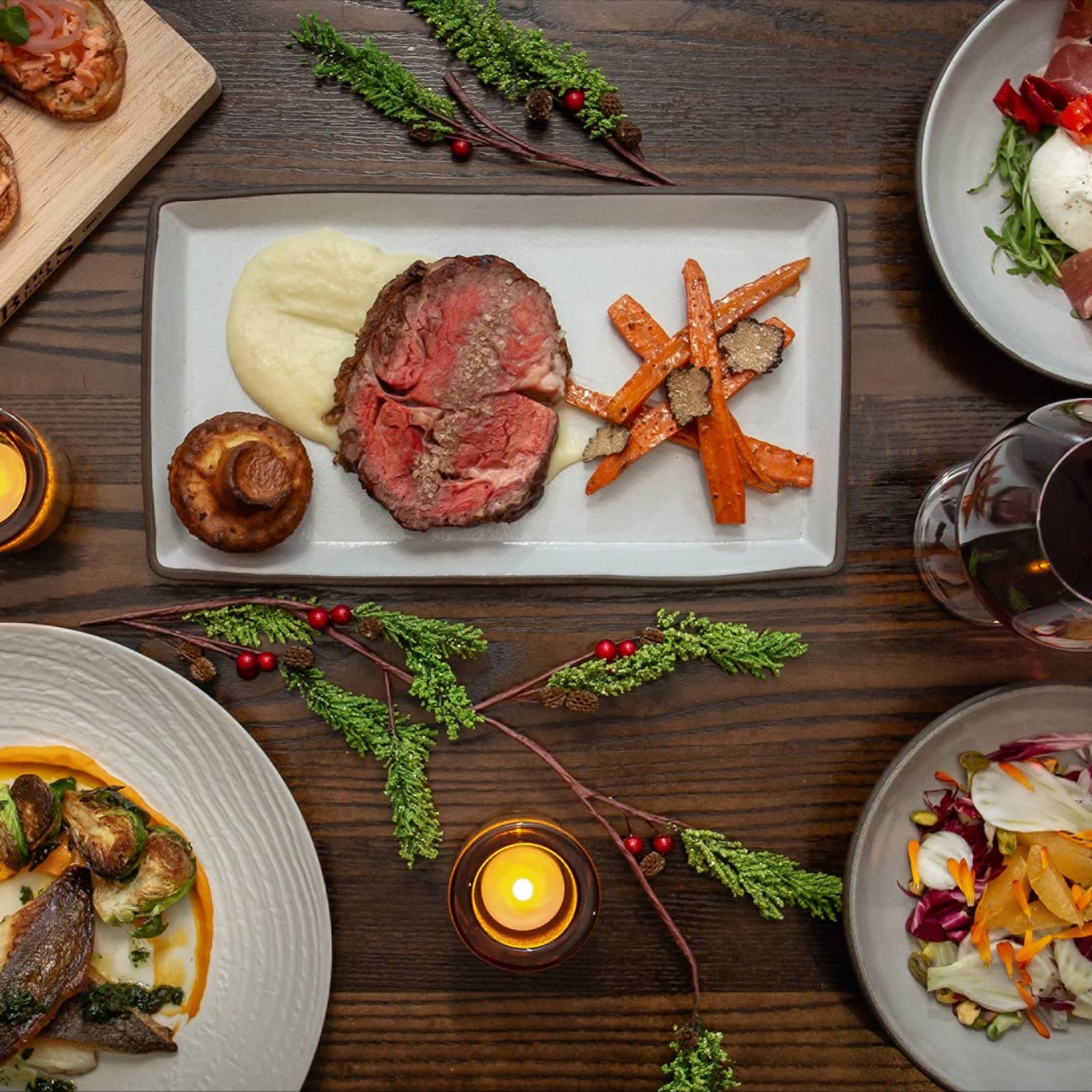 An assortment of holiday food on white and wood trays.